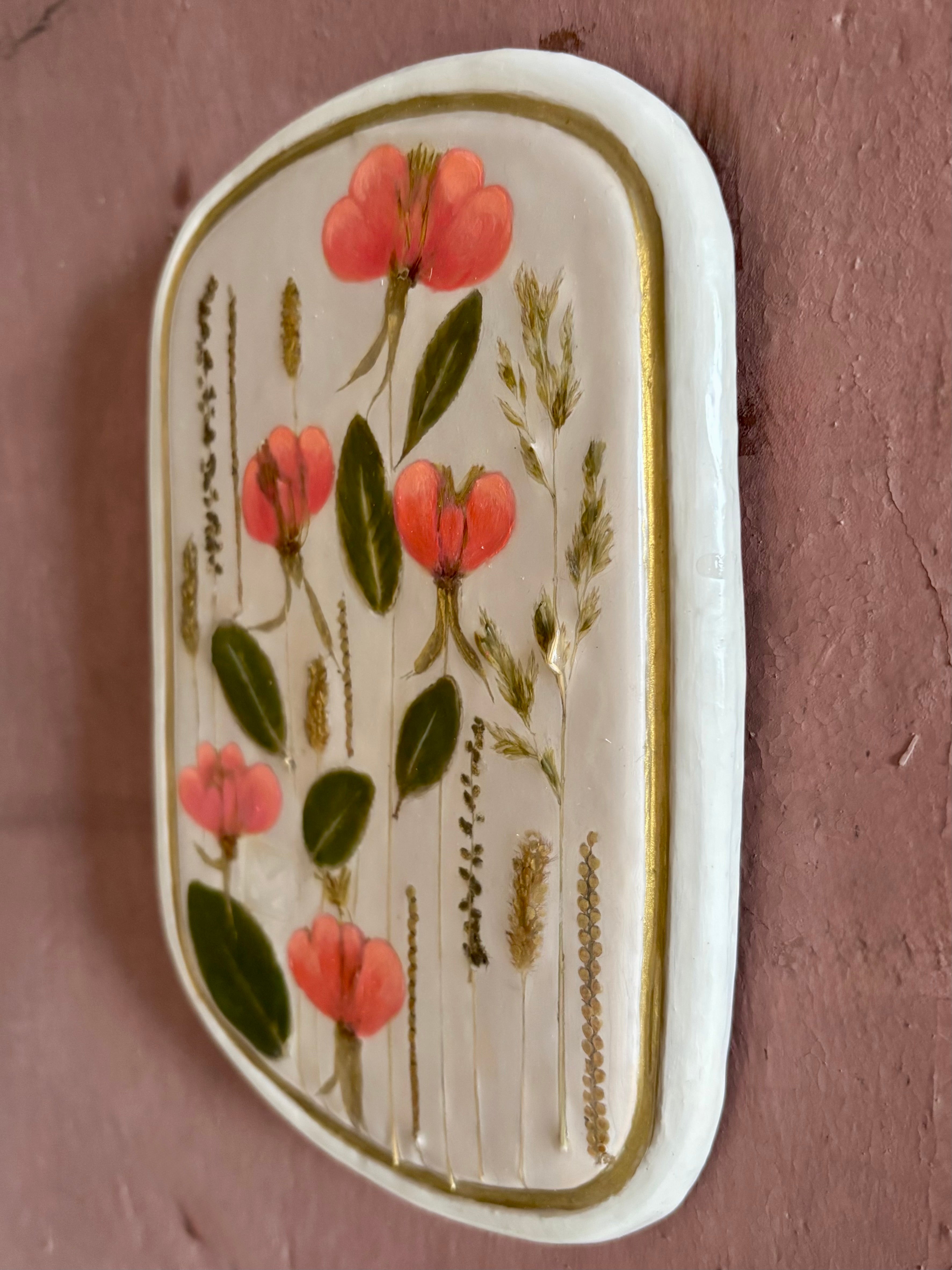 A rectangular ceramic tile with botanical pressed evening primrose flowers grasses and boxwoods on cream clay