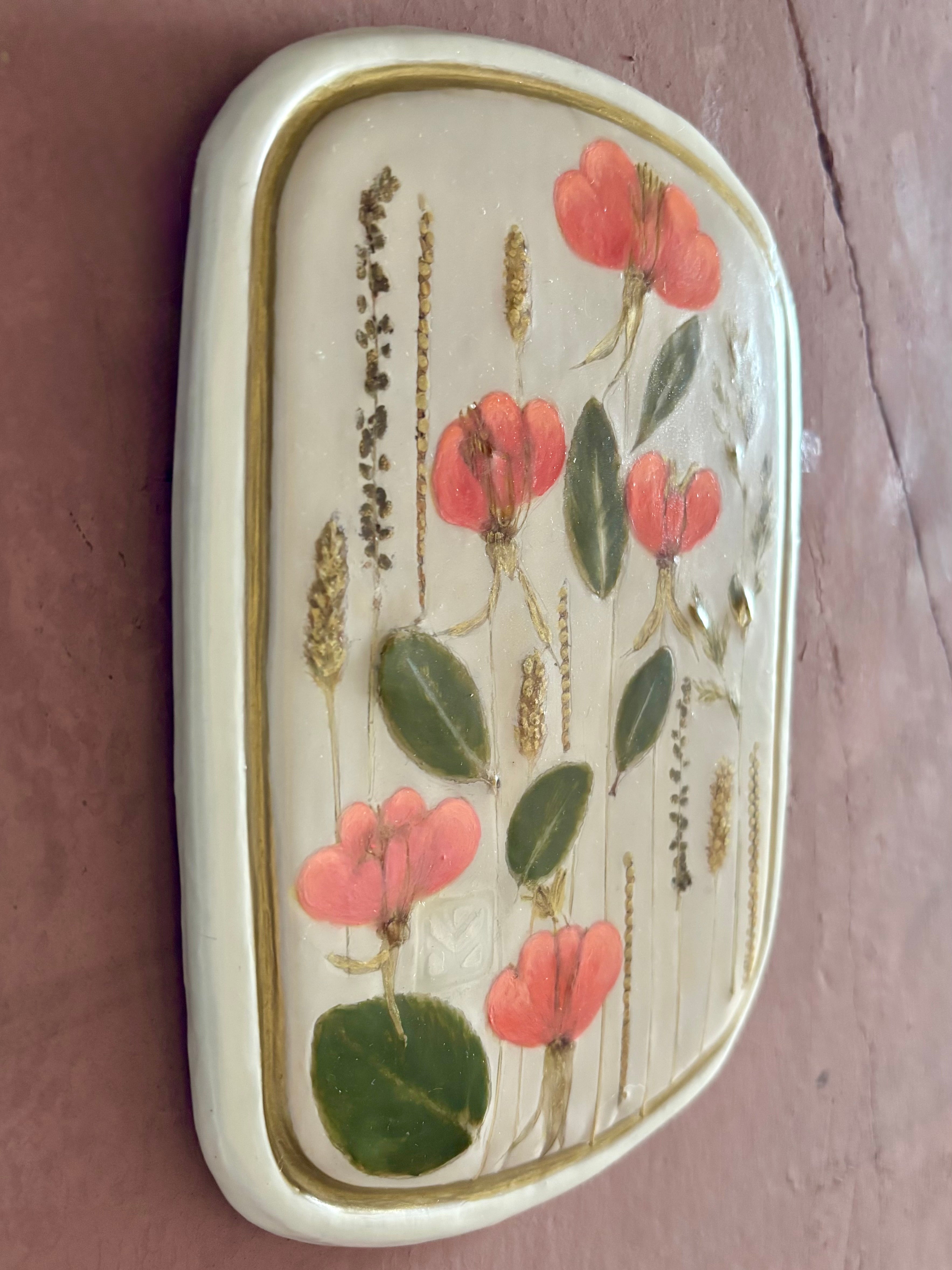 A rectangular ceramic tile with botanical pressed evening primrose flowers grasses and boxwoods on cream clay
