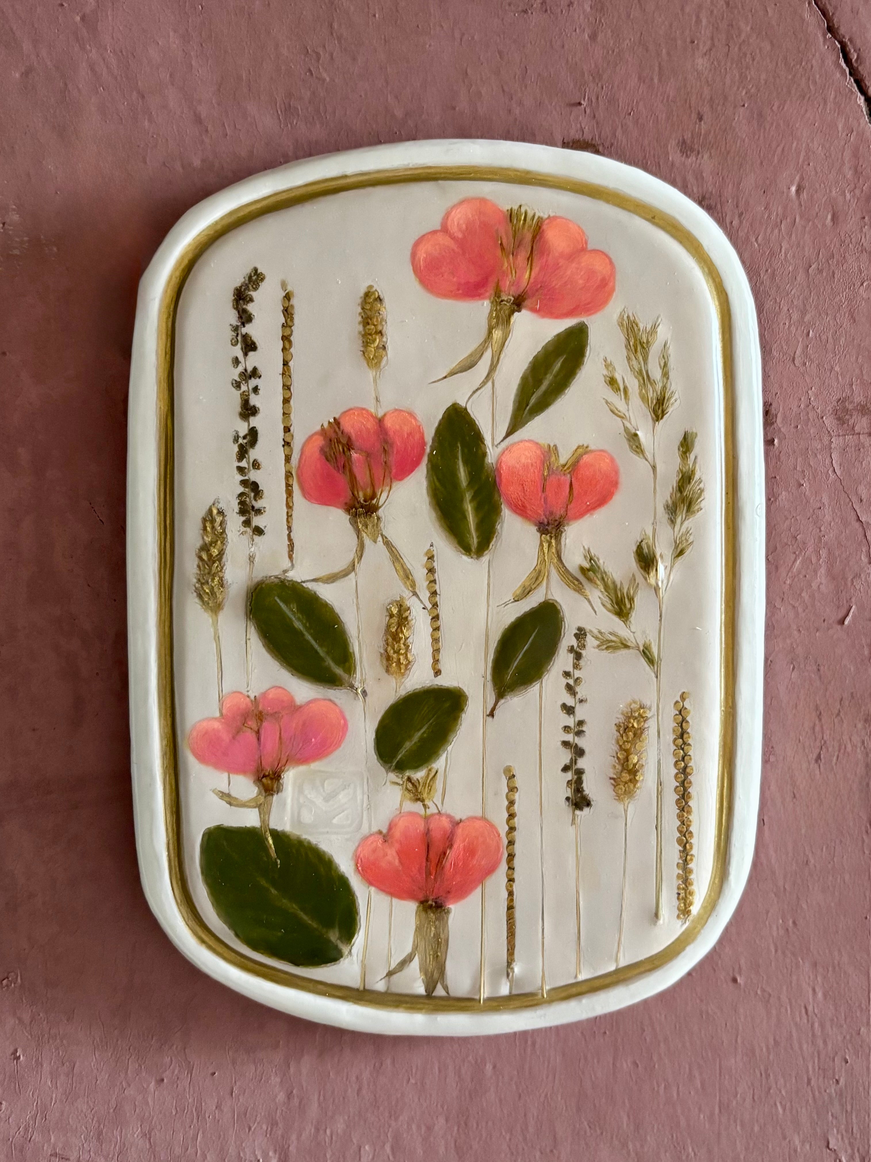 A rectangular ceramic tile with botanical pressed evening primrose flowers grasses and boxwoods on cream clay