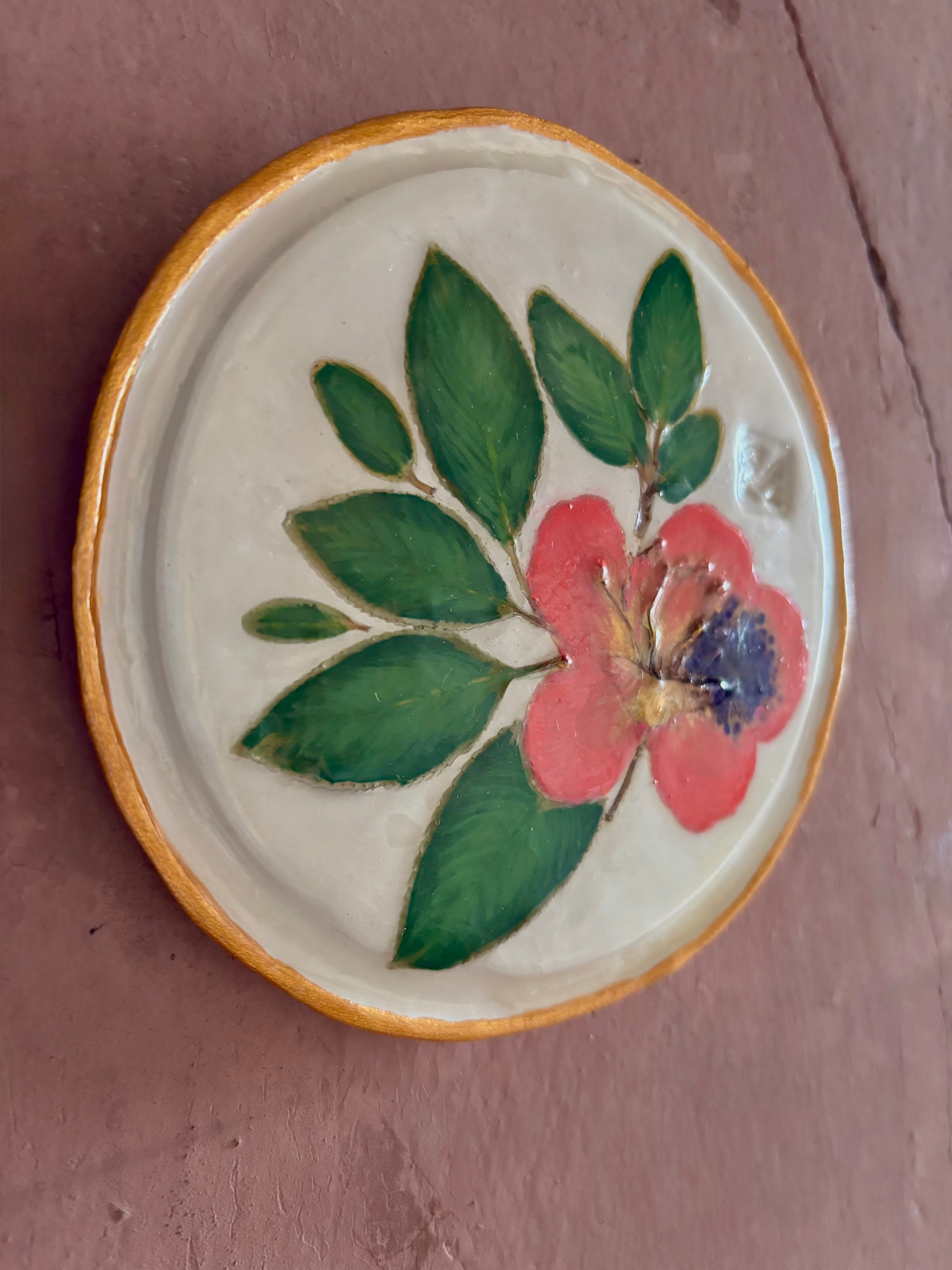 A round white ceramic tile with sappora rhododendron bloom botanical press green leaves and hand painted gold rim