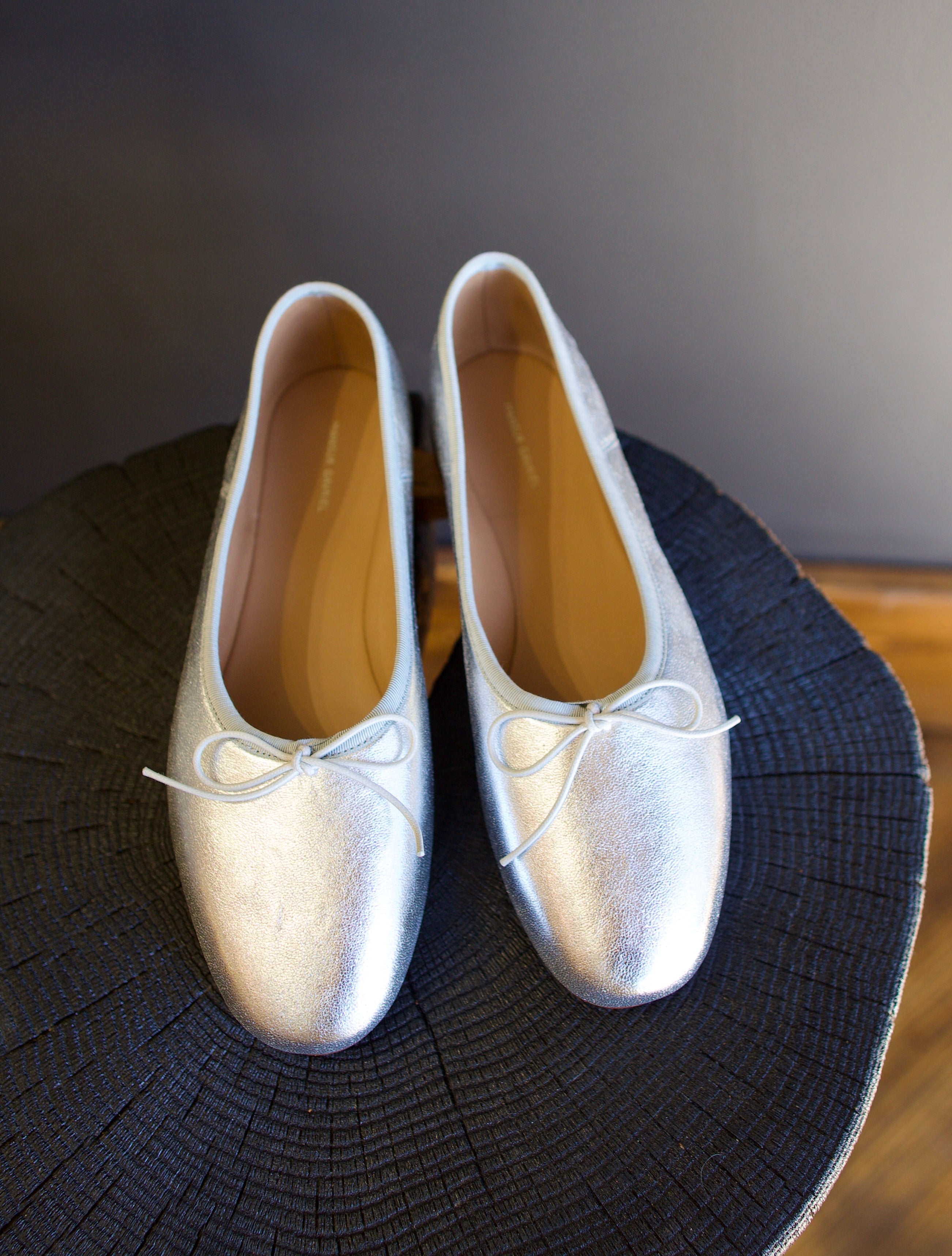 Image featuring the Dream Ballerina Flats by Mansur Gavriel with a small bow with a round toe and flat heel in matte silver.