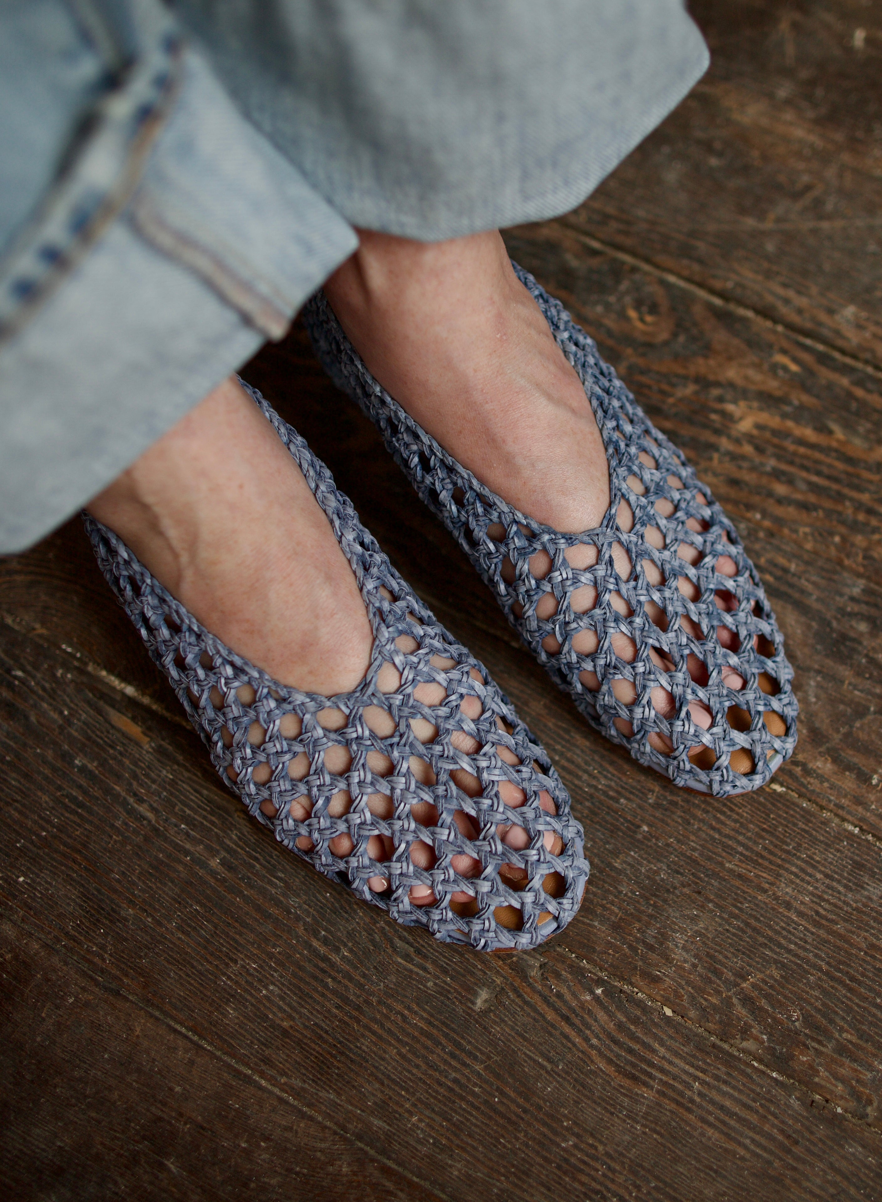 Model showcasing intricately woven luxury footwear casual blue ballerina flats by Mansur Gavriel