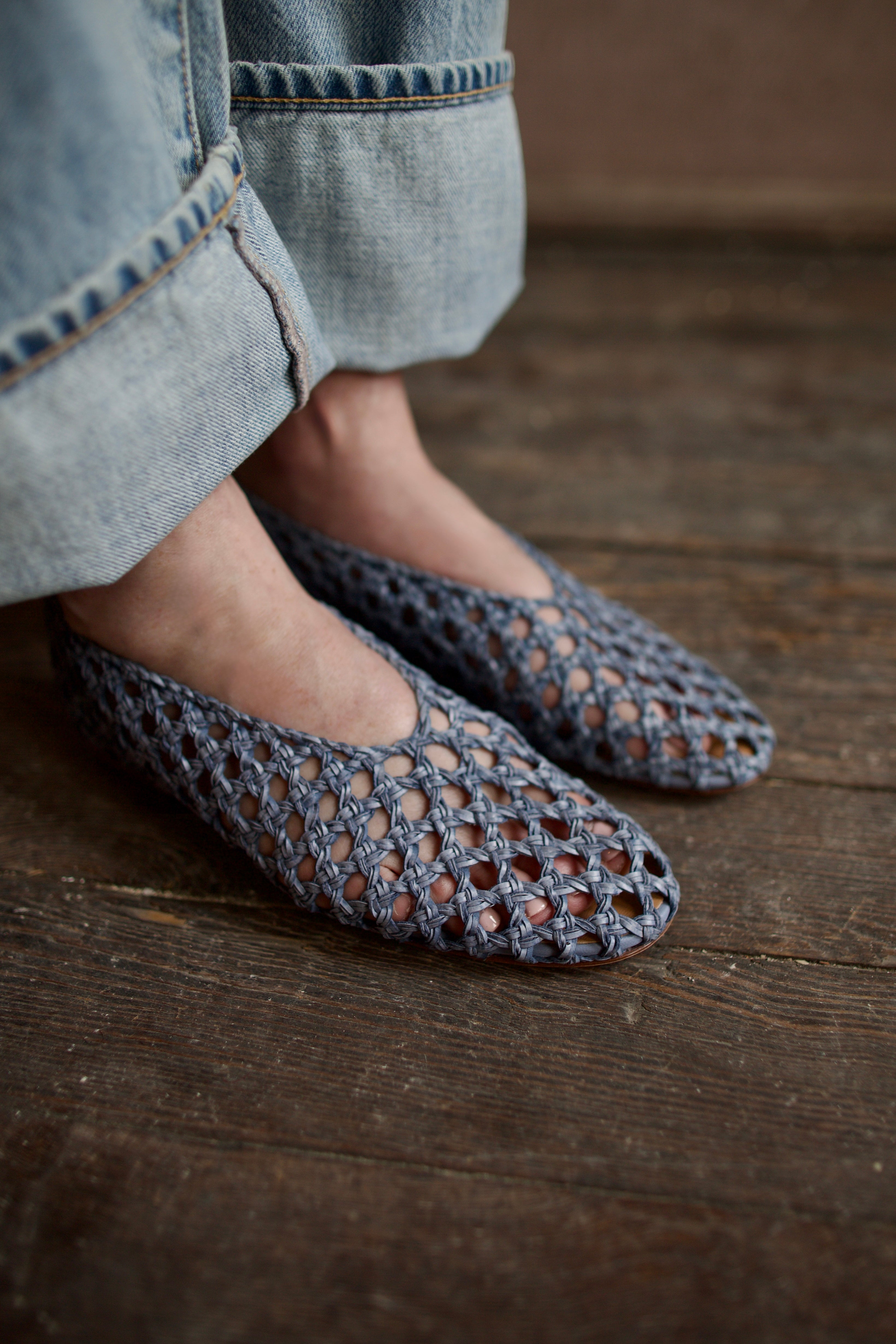 Model showcasing intricately woven women's luxury footwear casual blue ballerina flats by Mansur Gavriel