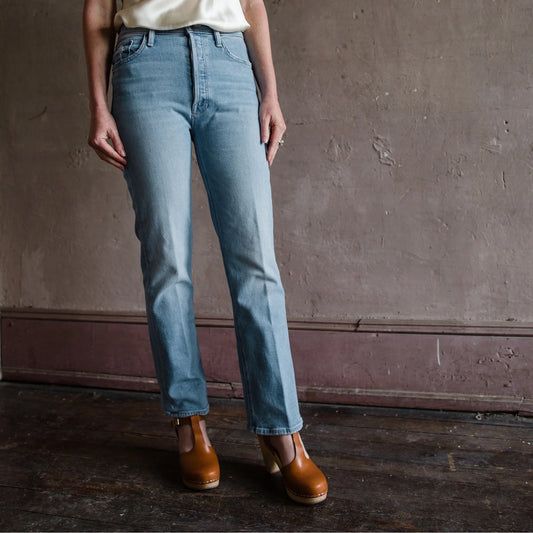 Image featuring a woman wearing the Mother denim is a high-rise ankle length straight leg jean featuring a finished hem.