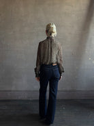 Mature woman wearing Nili Lotan Silk Demie Blouse in Brown/Cream Wild Dots sheer mock neck and keyhole back closure. Made in the USA