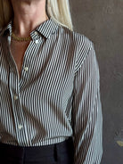 Mature woman wearing Nili Lotan Gaia Slim Silk Shirt in Dark Brown/Cream Stripe classic button front Made in the USA
