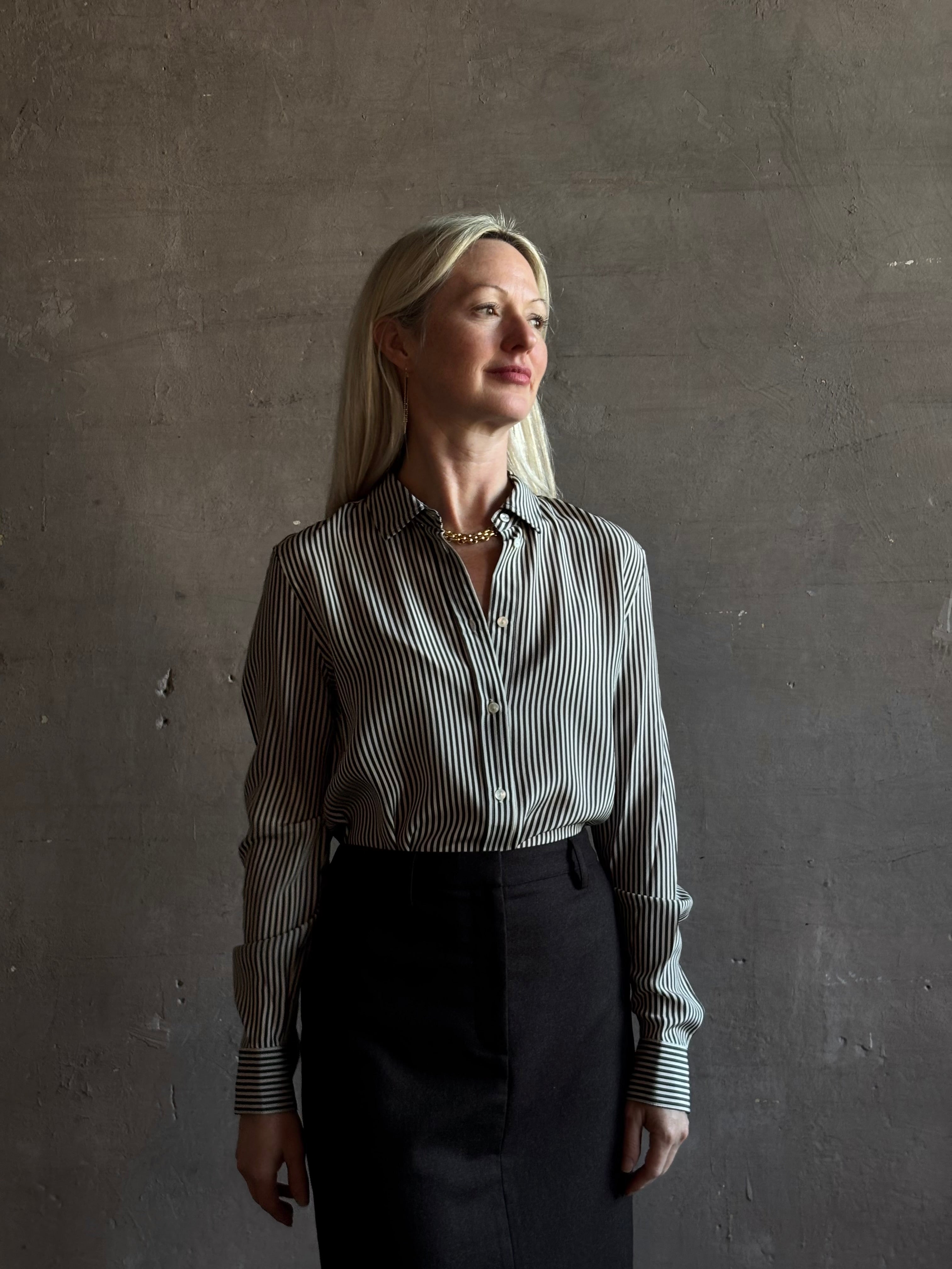 Mature woman wearing Nili Lotan Gaia Slim Silk Shirt in Dark Brown/Cream Stripe classic collar, cuffed sleeves Made in the USA