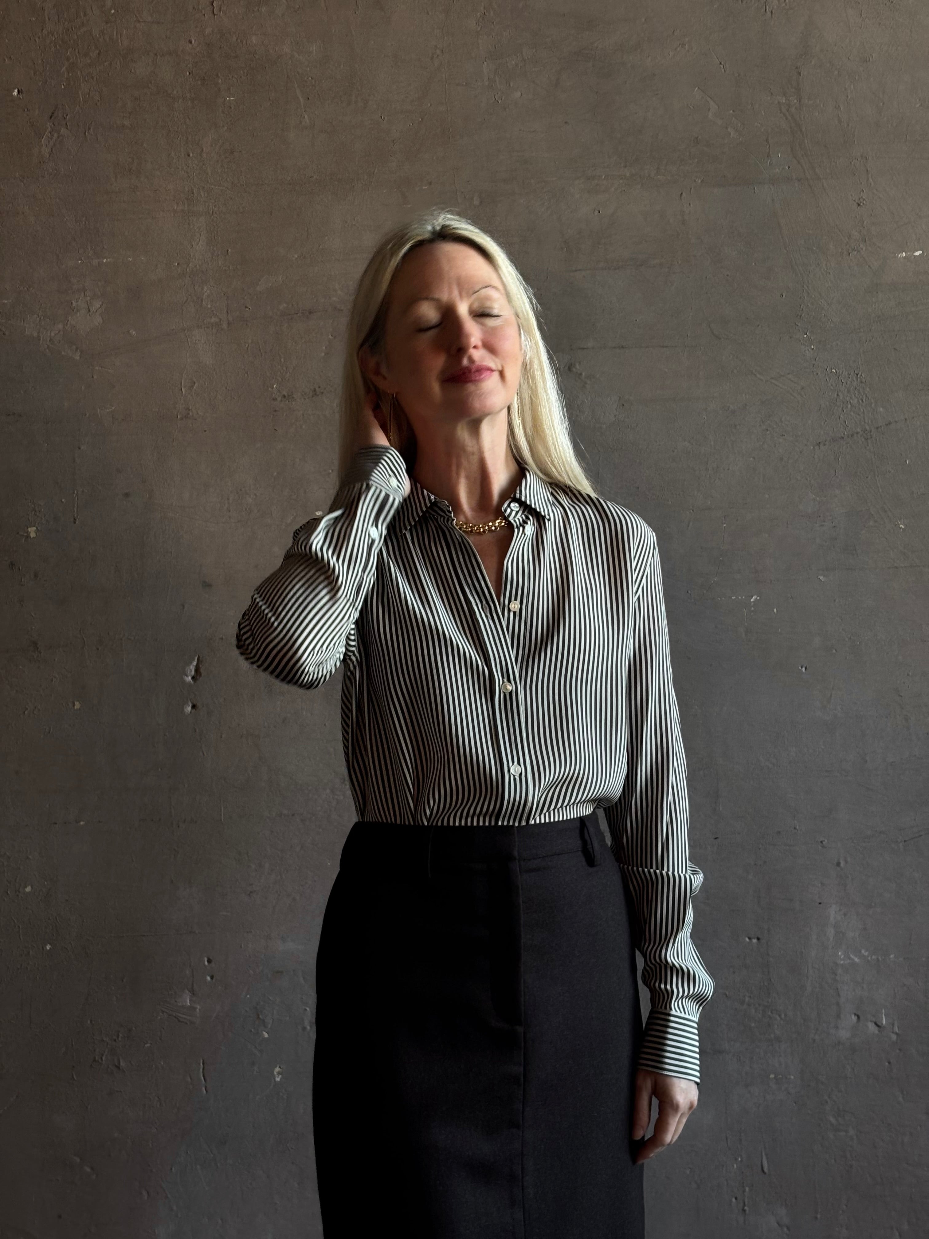 Mature woman wearing Nili Lotan Gaia Slim Silk Shirt in Dark Brown/Cream Stripe classic collar, cuffed sleeves Made in the USA