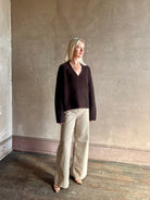 Mature woman wearing Nili Lotan's Isley Sweater Dark brown cashmere-silk  relaxed V-neck silhouette. Ultra-luxe