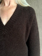 Mature woman wearing Nili Lotan's Isley Sweater Dark brown cashmere-silk  relaxed V-neck silhouette. Ultra-luxe