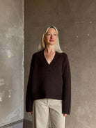 Mature woman wearing Nili Lotan's Isley Sweater Dark brown cashmere-silk  relaxed V-neck silhouette. Ultra-luxe
