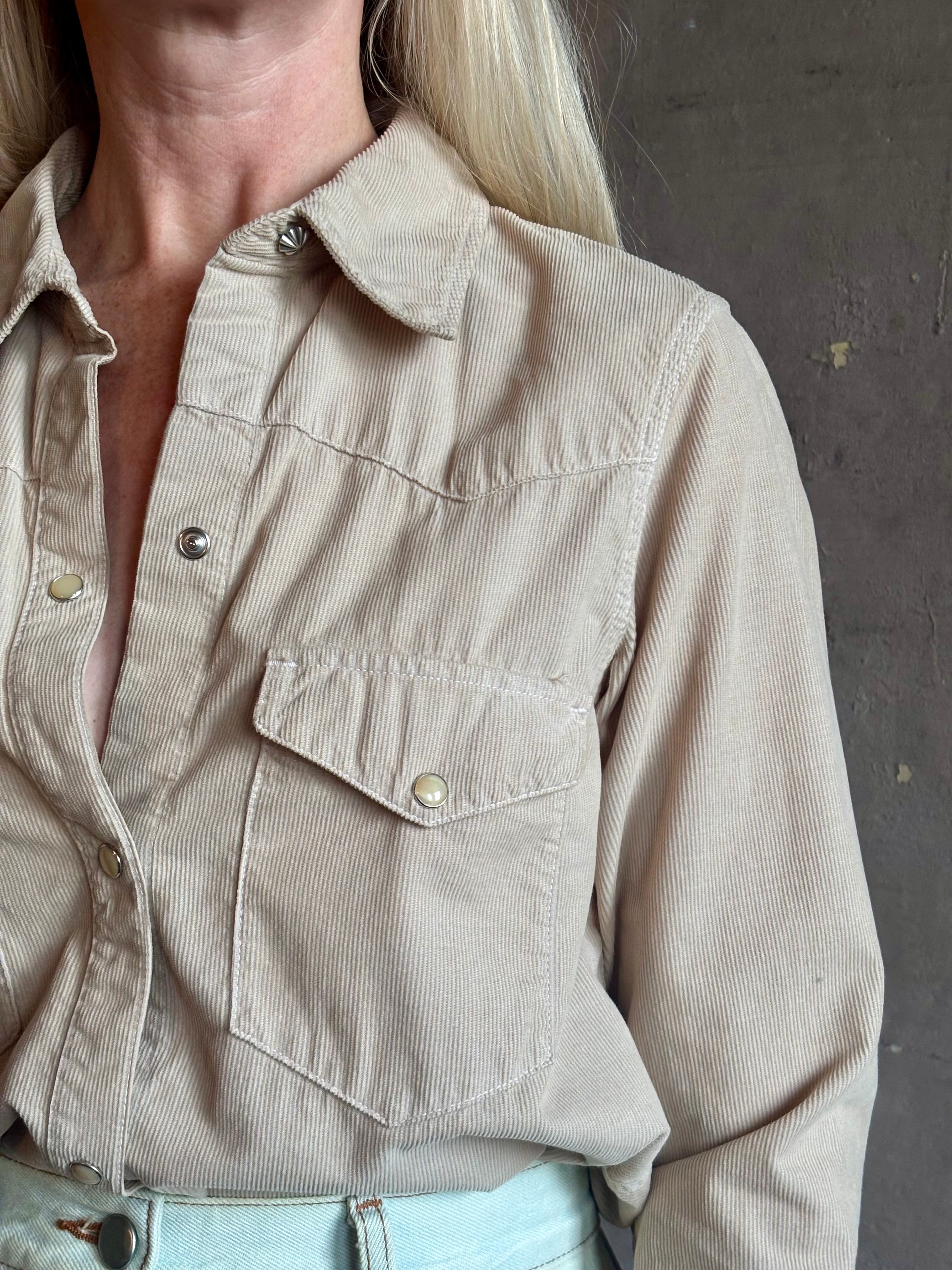 Mature woman wearing Nili Lotan's Travis Corduroy Shirt in Travertine cotton corduroy Western-inspired snap buttons