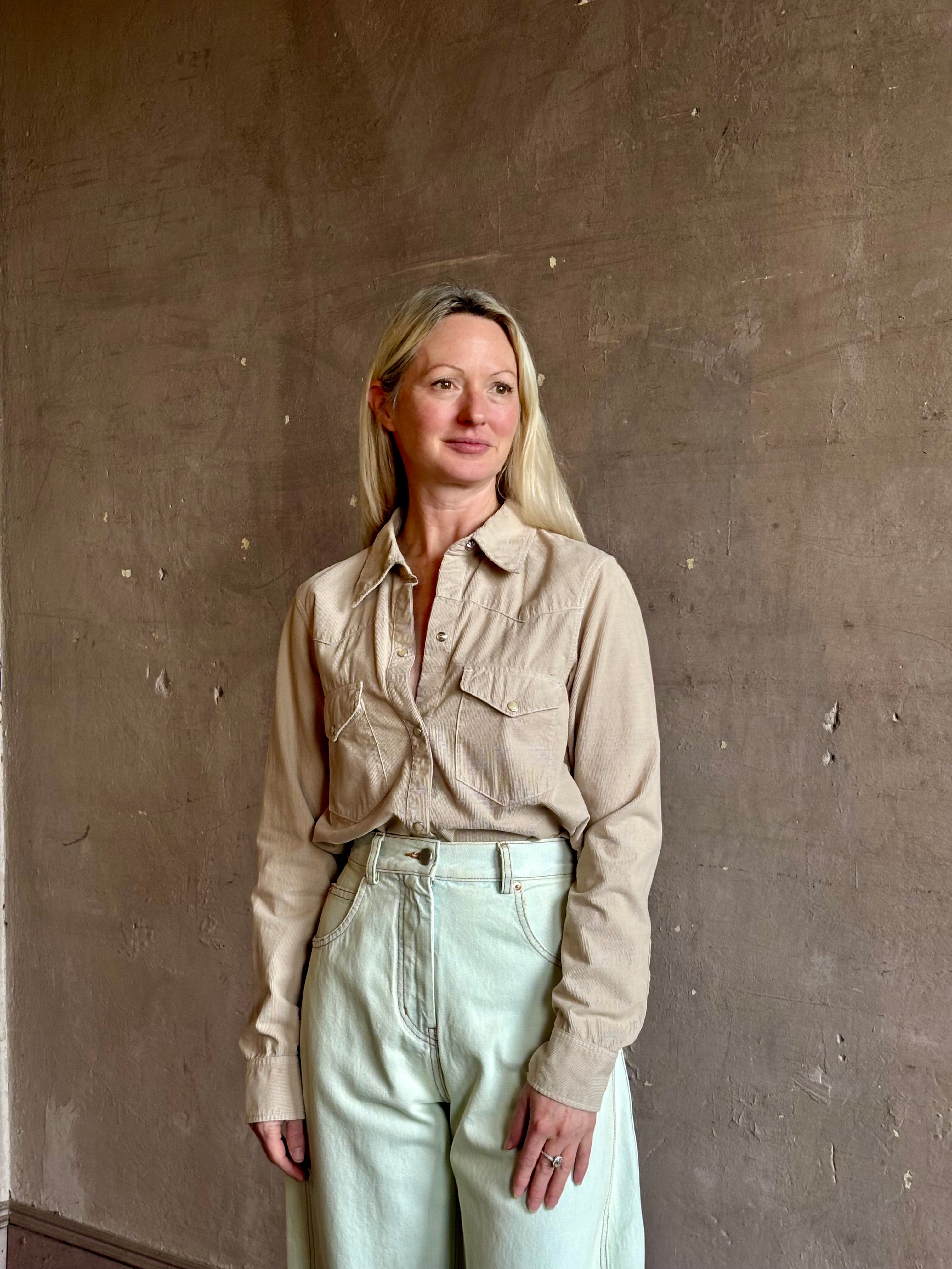 Mature woman wearing Nili Lotan's Travis Corduroy Shirt in Travertine cotton corduroy Western-inspired snap buttons