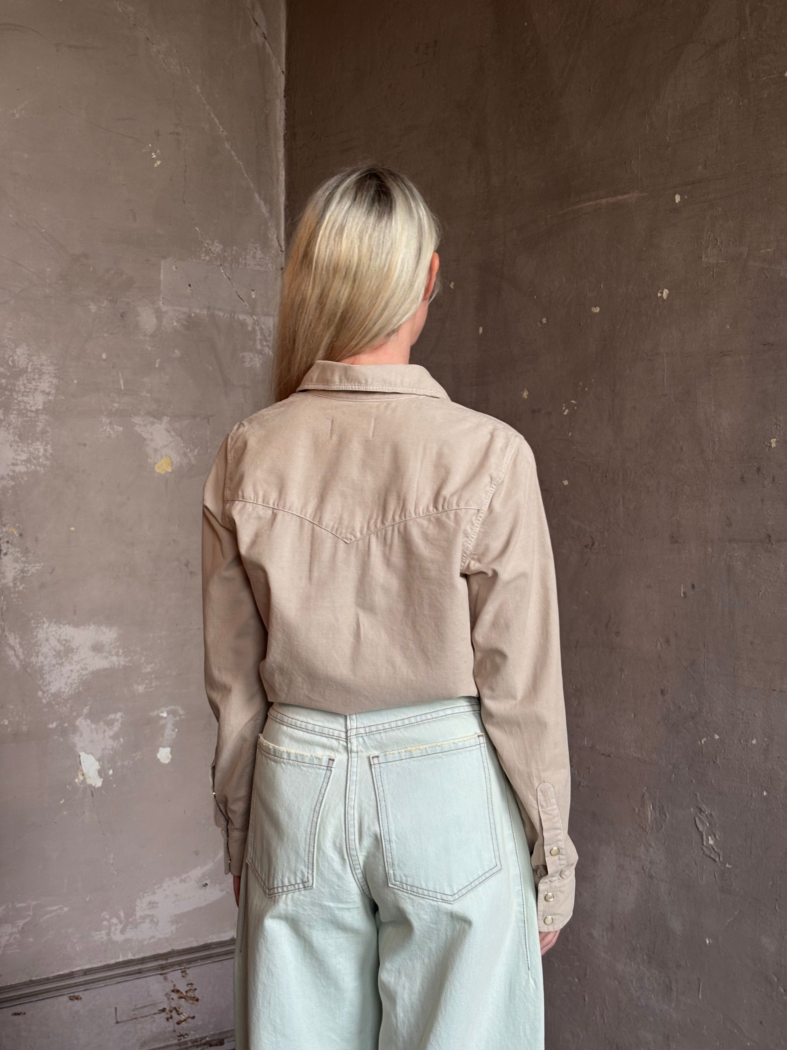 Mature woman wearing Nili Lotan's Travis Corduroy Shirt in Travertine cotton corduroy Western-inspired snap buttons