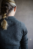 Close up back view of woman wearing Naadam featherweight cashmere polo in grey