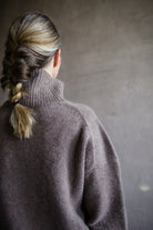 Close up back view of woman wearing Naadam luxe cashmere oversized turtleneck in brown