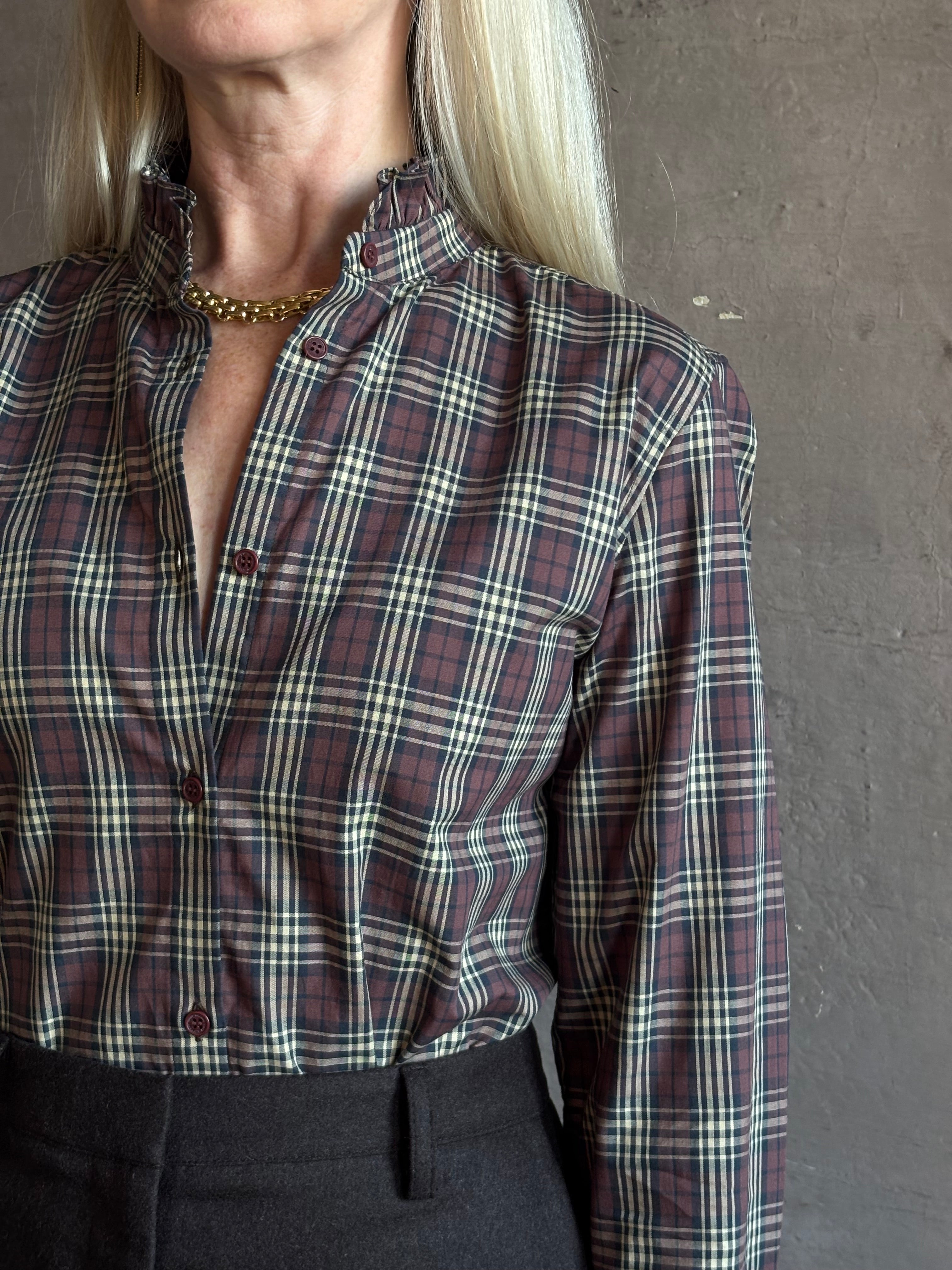 close up of Mature woman wearing Nili Lotan Elio Cotton Shirt in Rustic Check with a small ruffle lined mandarin collar in burgundy navy and khaki plaid print