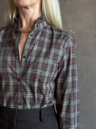 close up of Mature woman wearing Nili Lotan Elio Cotton Shirt in Rustic Check with a small ruffle lined mandarin collar in burgundy navy and khaki plaid print
