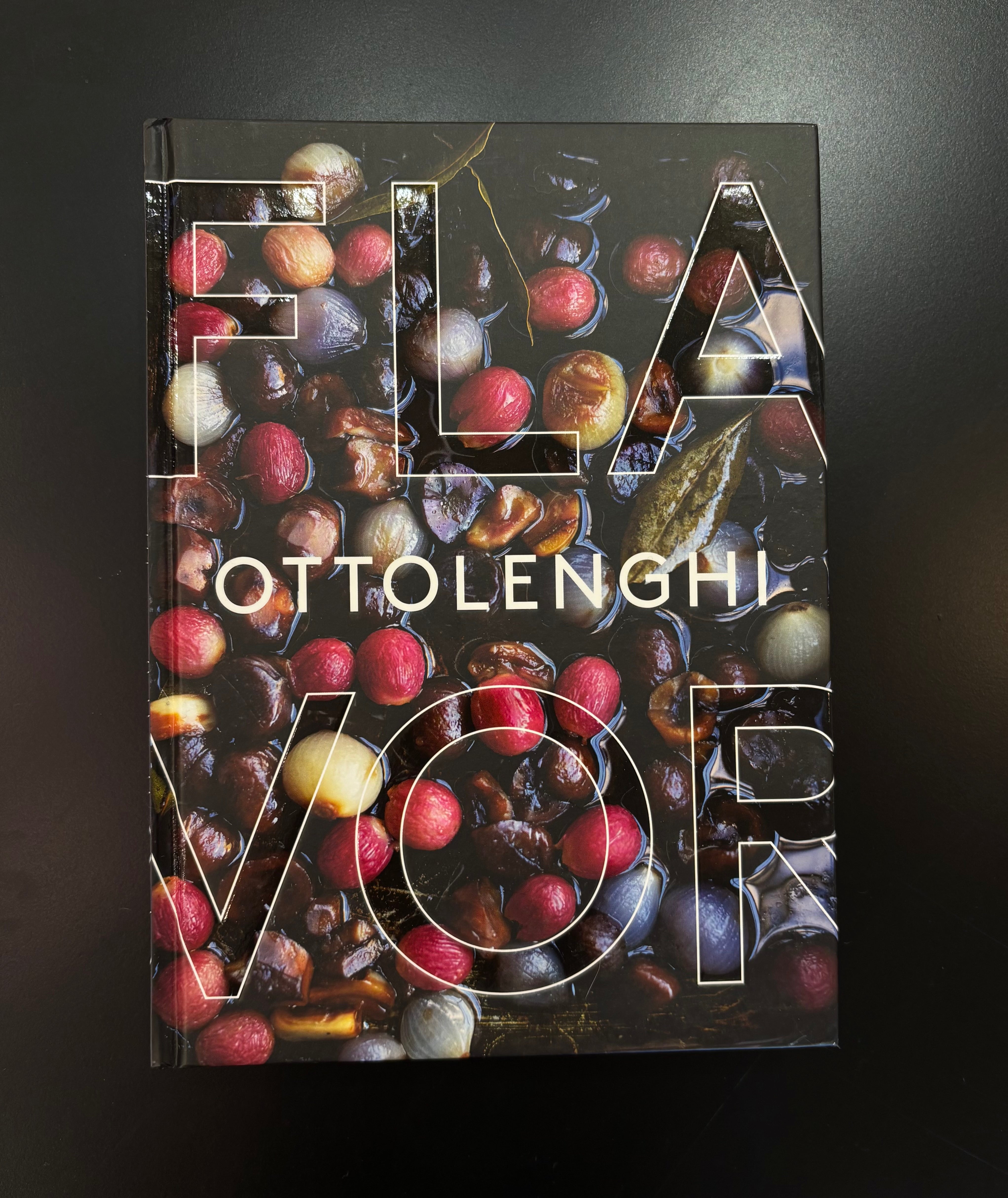 Ottolenghi's 'Flavor' cookbook with a glossy cover featuring a detailed photograph of roasted chestnuts and red fruits