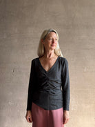 Woman wearing Proenza Schouler Blythe charcoal Top reversable long sleeves wool side ruching luxe draping
