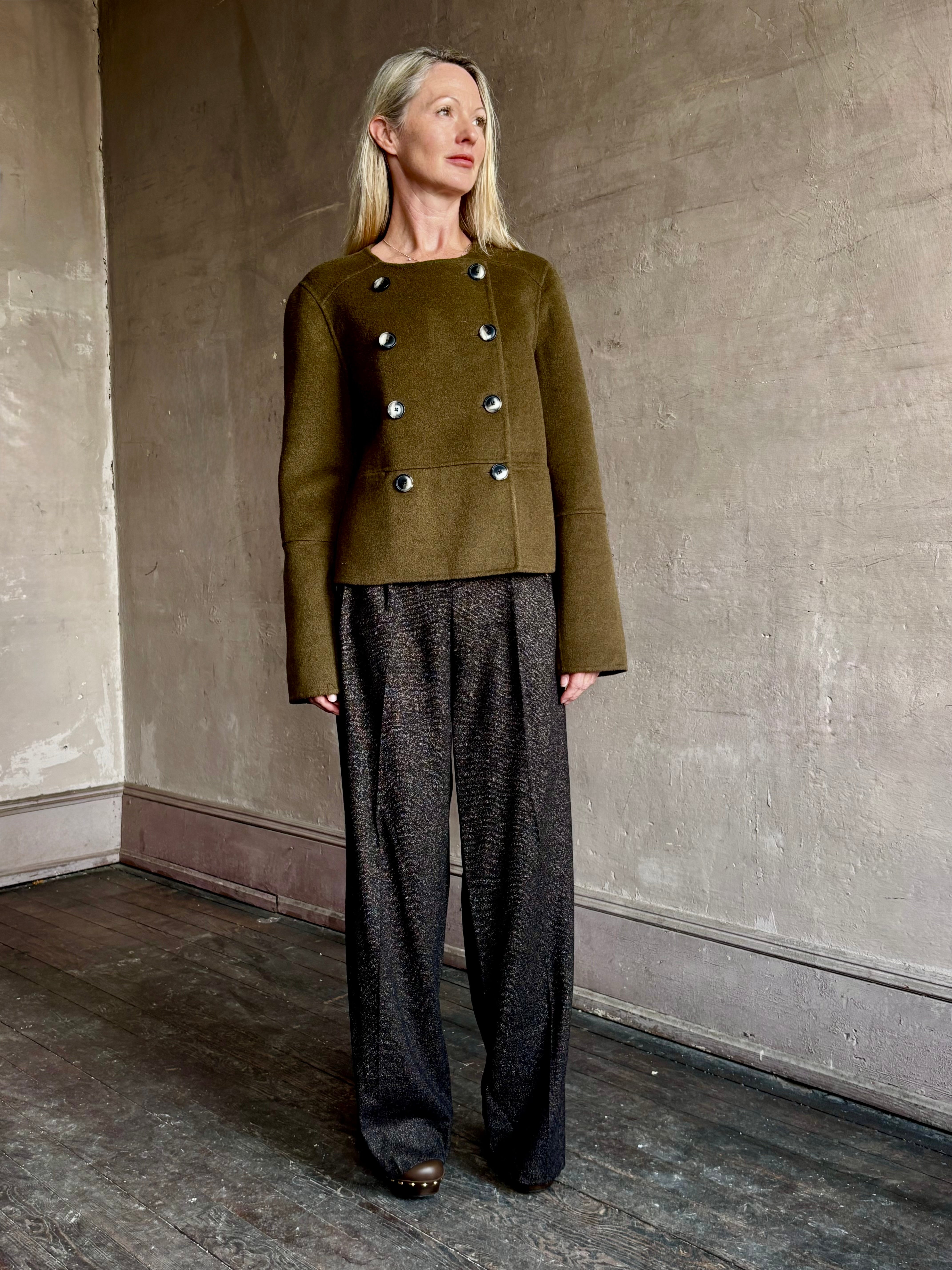 Image of mature woman wearing luxury brand Proenza Schouler cropped army green wool coat with subtle brown buttons
