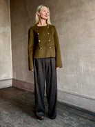 Image of mature woman wearing luxury brand Proenza Schouler cropped army green wool coat with subtle brown buttons