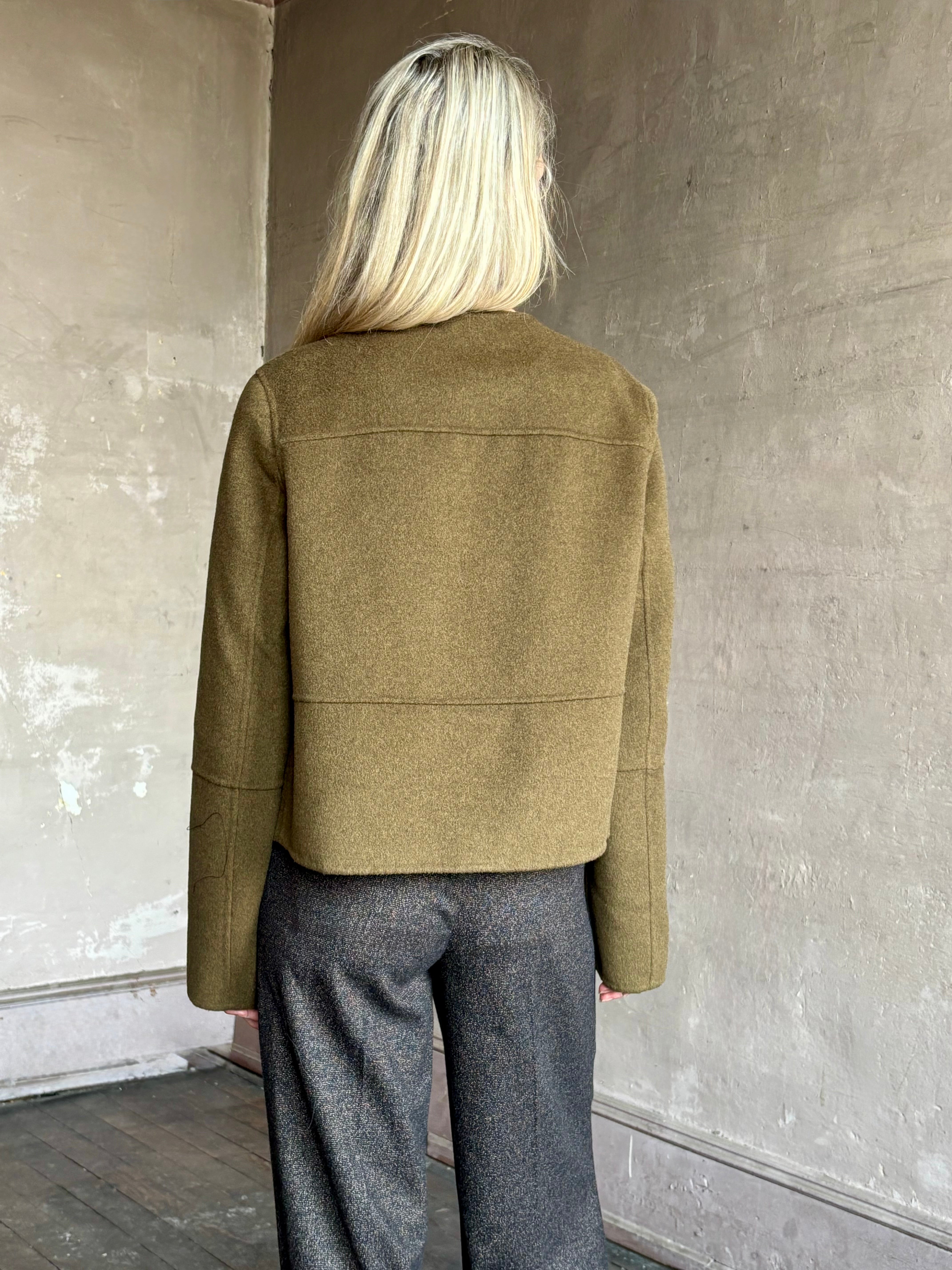 Image of mature woman wearing luxury brand Proenza Schouler cropped army green wool coat with beautiful seam details at back and sleeves