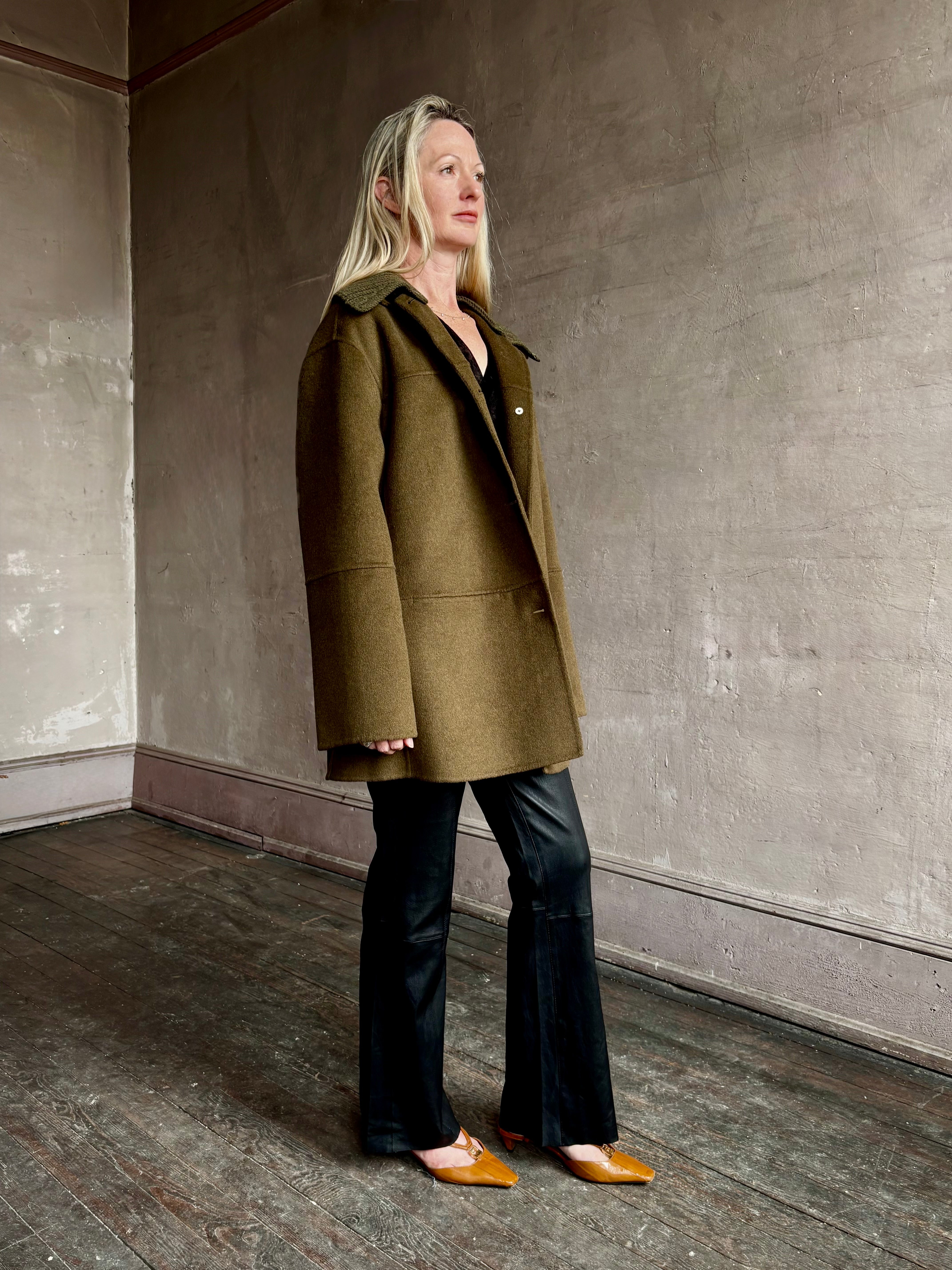 Image of woman wearing luxury brand Proenza Schoulder double faced green wool coat with detachable collar and front pockets
