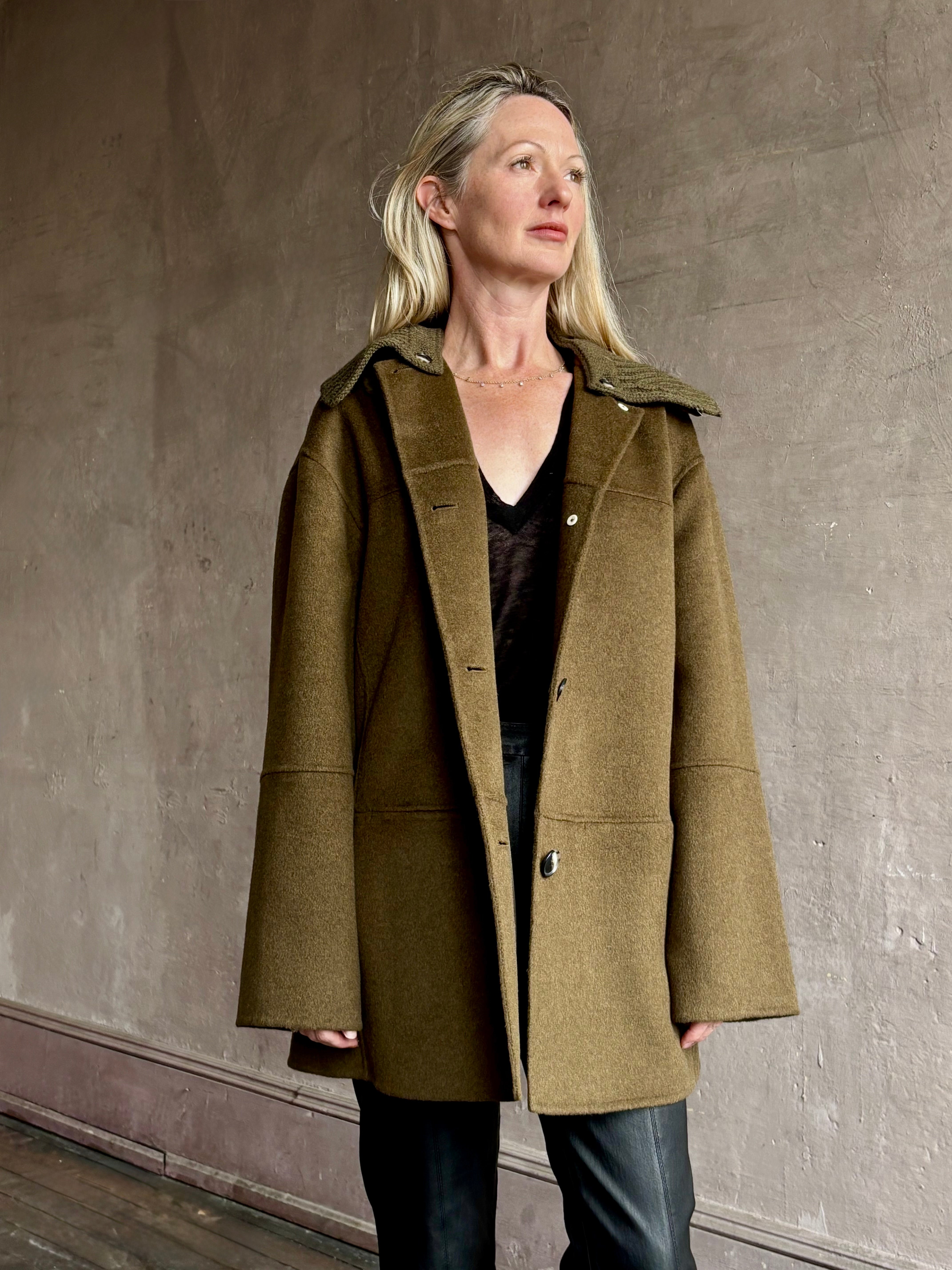 Image of woman wearing luxury brand Proenza Schoulder double faced green wool coat with detachable collar and front pockets