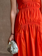 Mature woman wearing  Michelyn maxi designer Dress from Proenza Schouler rendered in a striking orange and crafted from a refined cotton blend with adjustable spaghetti straps, v-neck, pockets, hidden zipper closure and modern ruching details