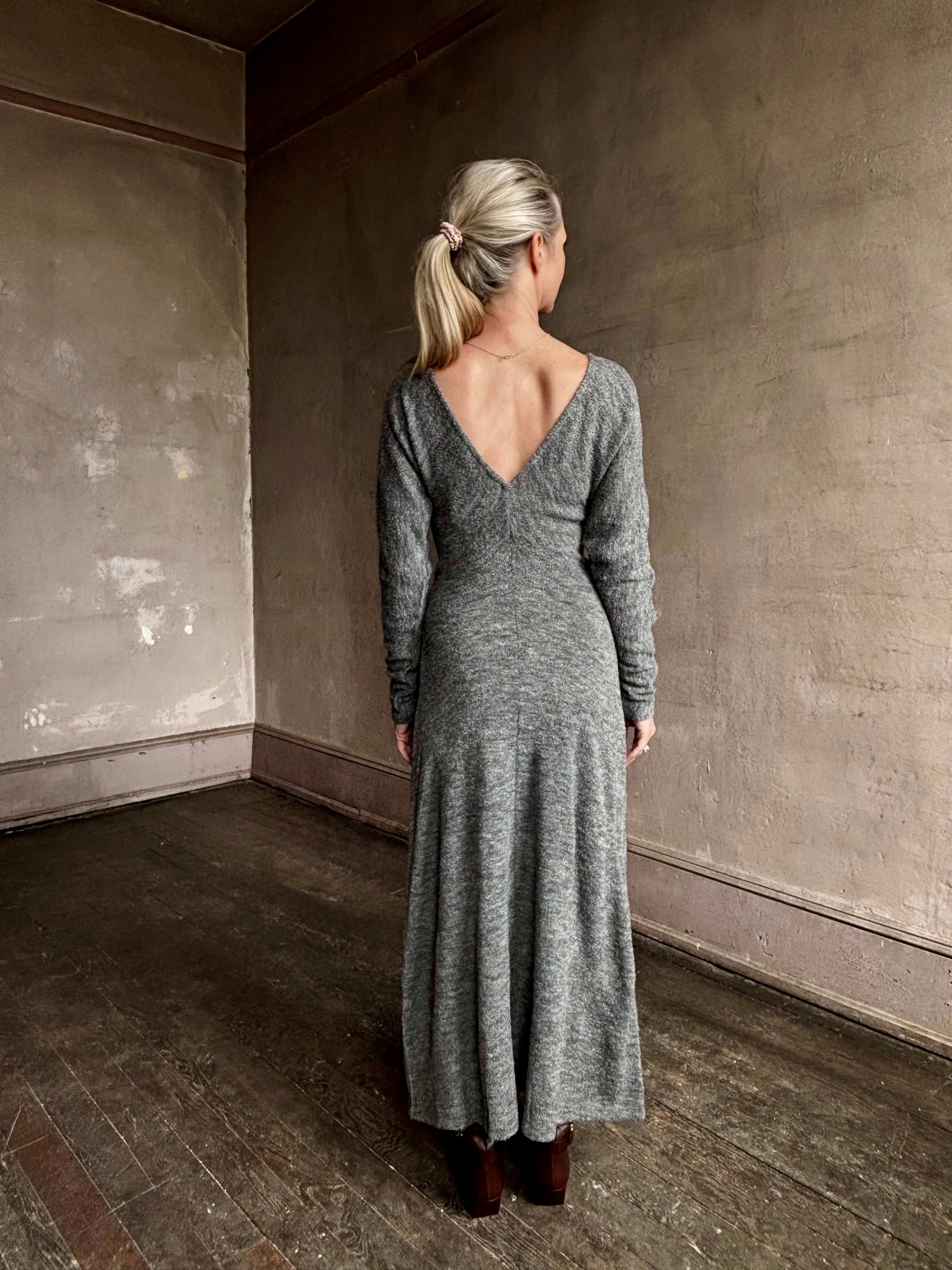 Image of mature woman wearing Proenza Schouler Sai maxi Dress in wool jersey grey with deep V back, long sleeves and draping skirt