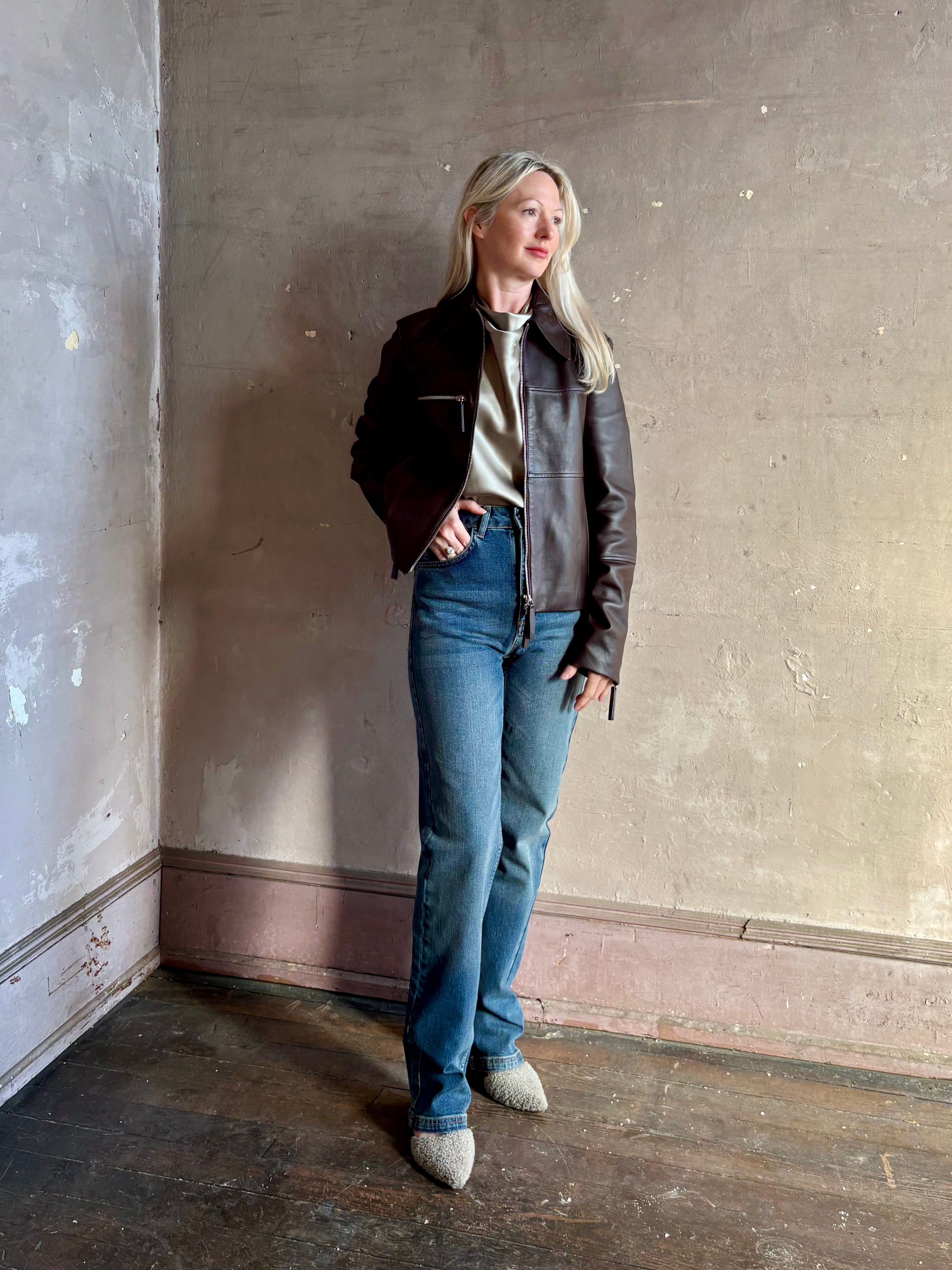 Mature woman wearing Proenza Schouler White Label Annabel lambskin Leather biker Jacket in Chocolate Brown with two way front zipper and straight hem