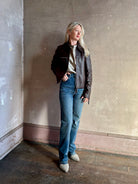 Mature woman wearing Proenza Schouler White Label Annabel lambskin Leather biker Jacket in Chocolate Brown with two way front zipper and straight hem