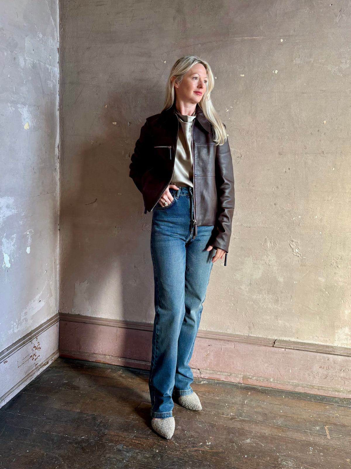 Mature woman wearing Proenza Schouler White Label Annabel lambskin Leather biker Jacket in Chocolate Brown with two way front zipper and straight hem