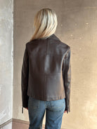 Back view of mature woman wearing Proenza Schouler White Label Annabel Leather Jacket in Chocolate Brown with intricate seam details