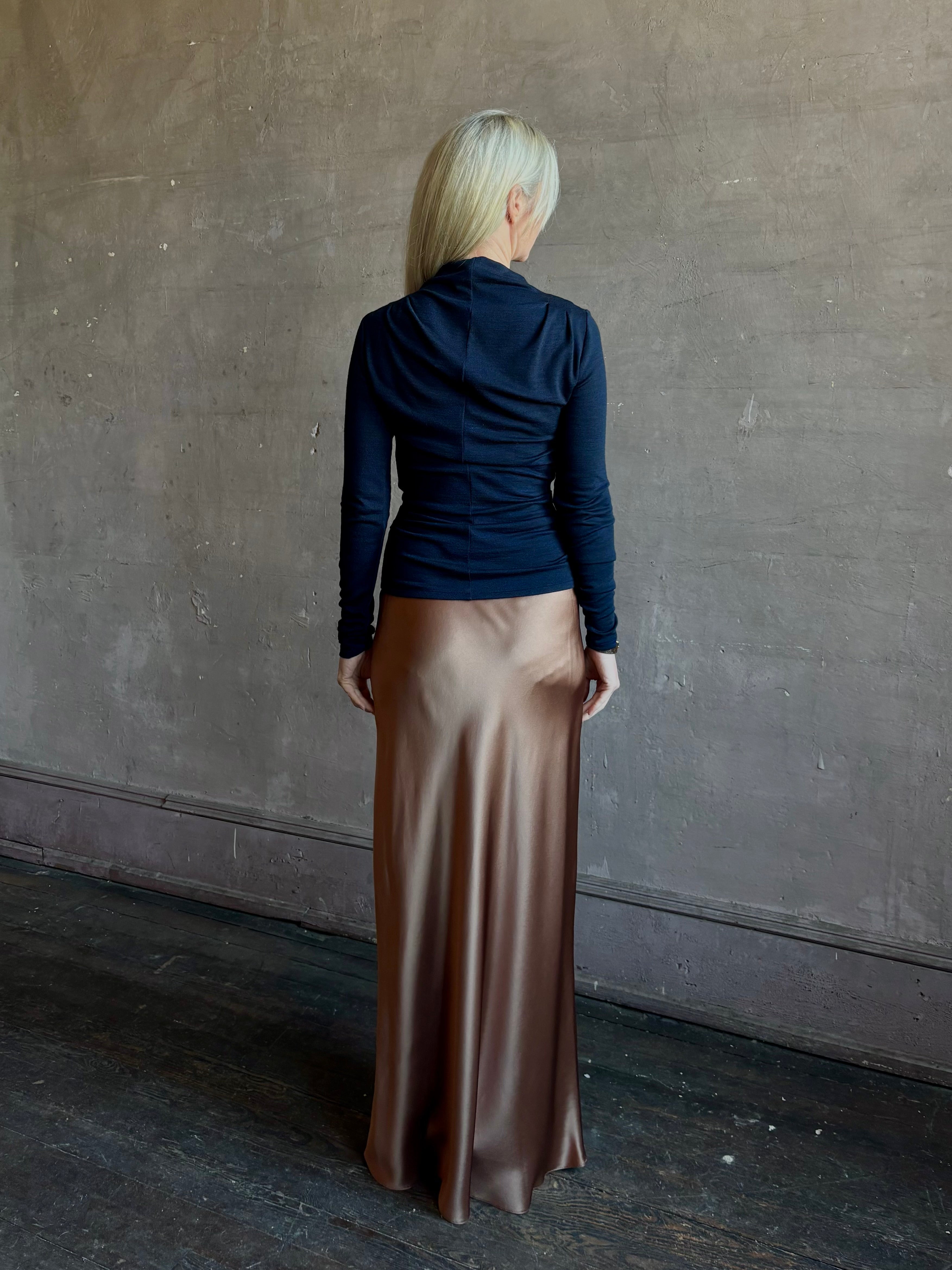 Back image of mature woman wearing Proenza Schouler Mini Jersey Top with shoulder pleats and fluid draping at back with fabric seam down center of back