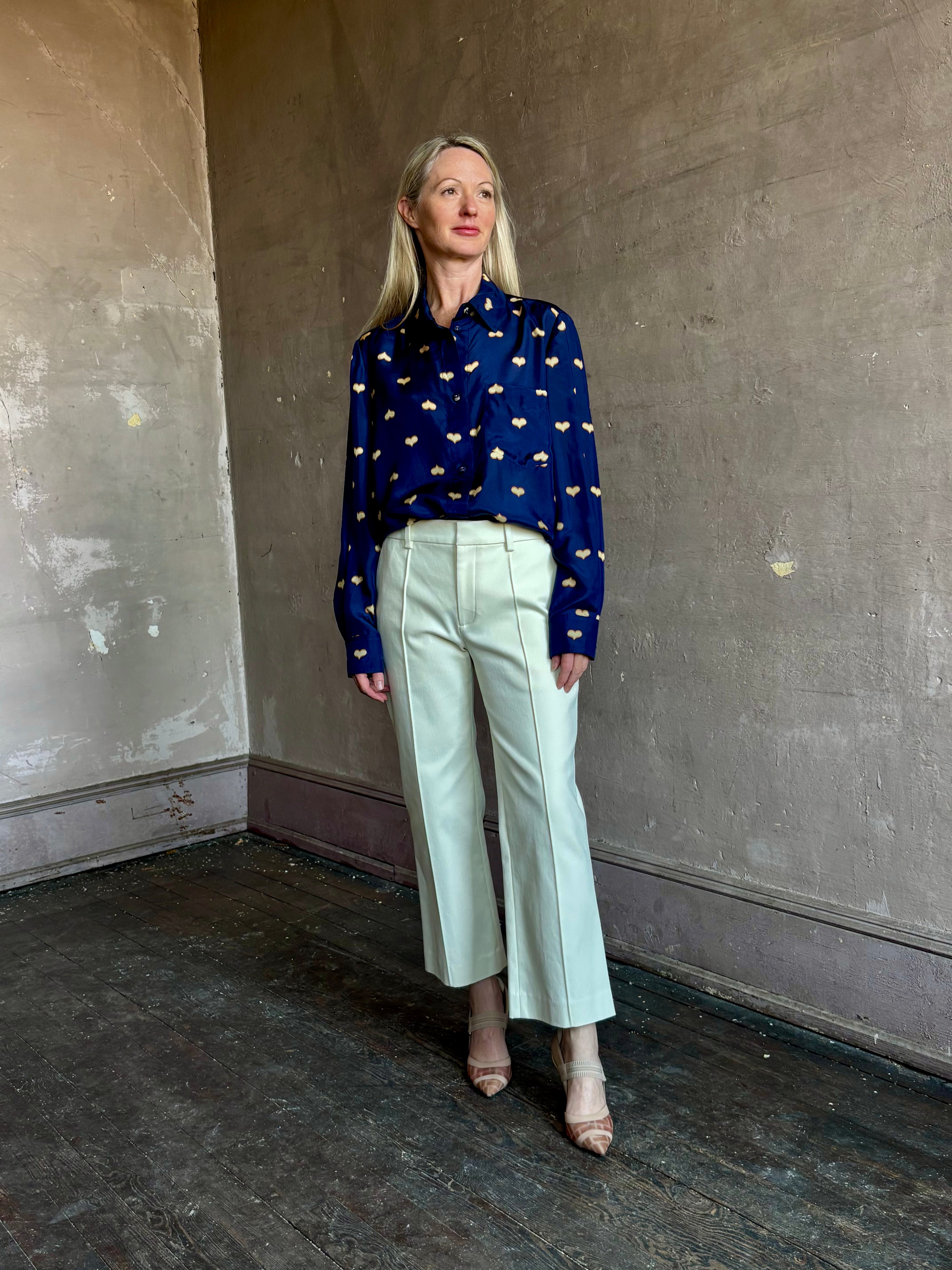 Image of mature woman wearing New York designer Rachel Comey navy silk Lilo button down with long sleeves and heart print with contemporary American style.