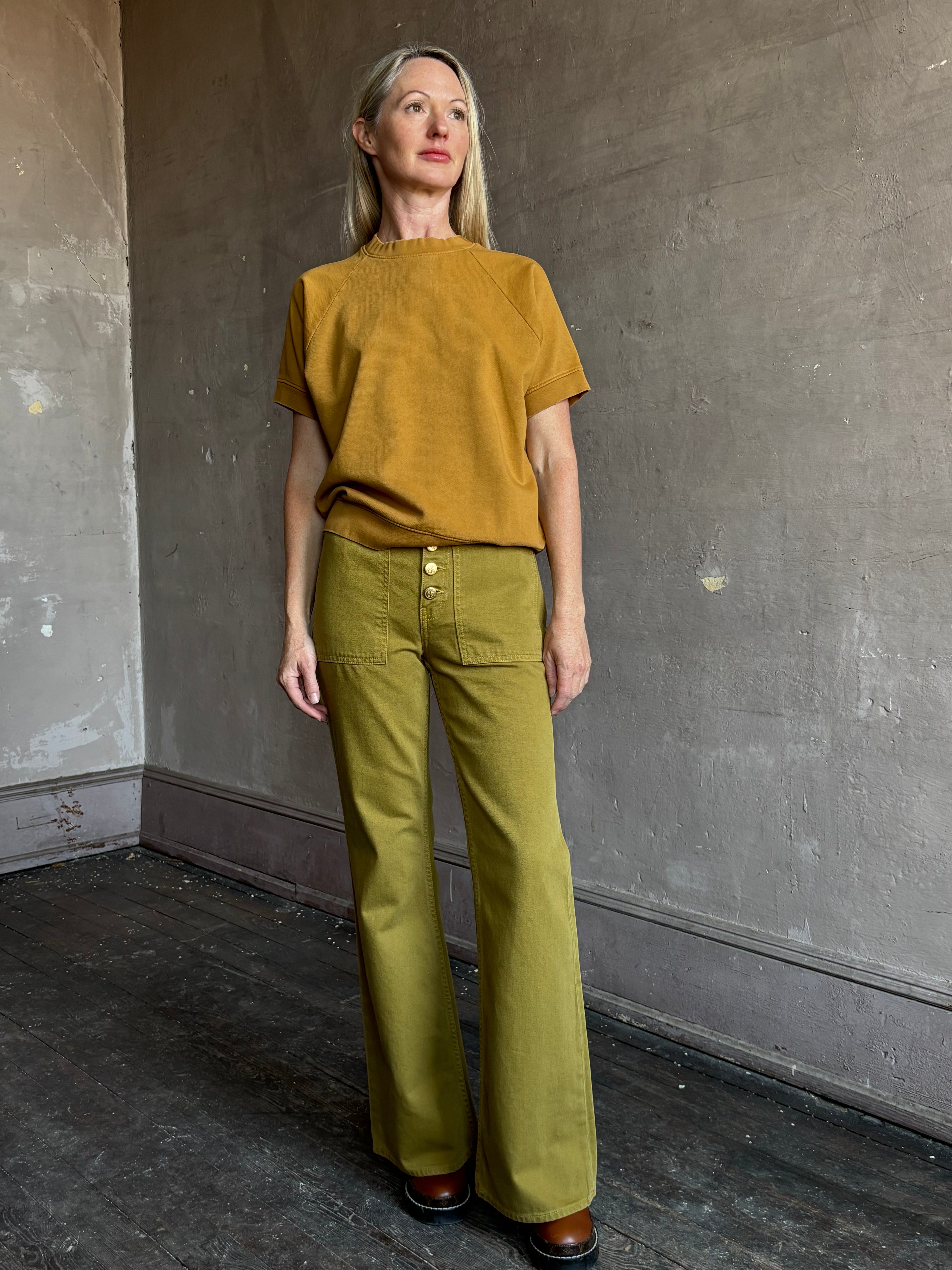 Image of mature woman wearing NY designer Rachel Comey Billi short sleeve sweatshirt in mustard gold 