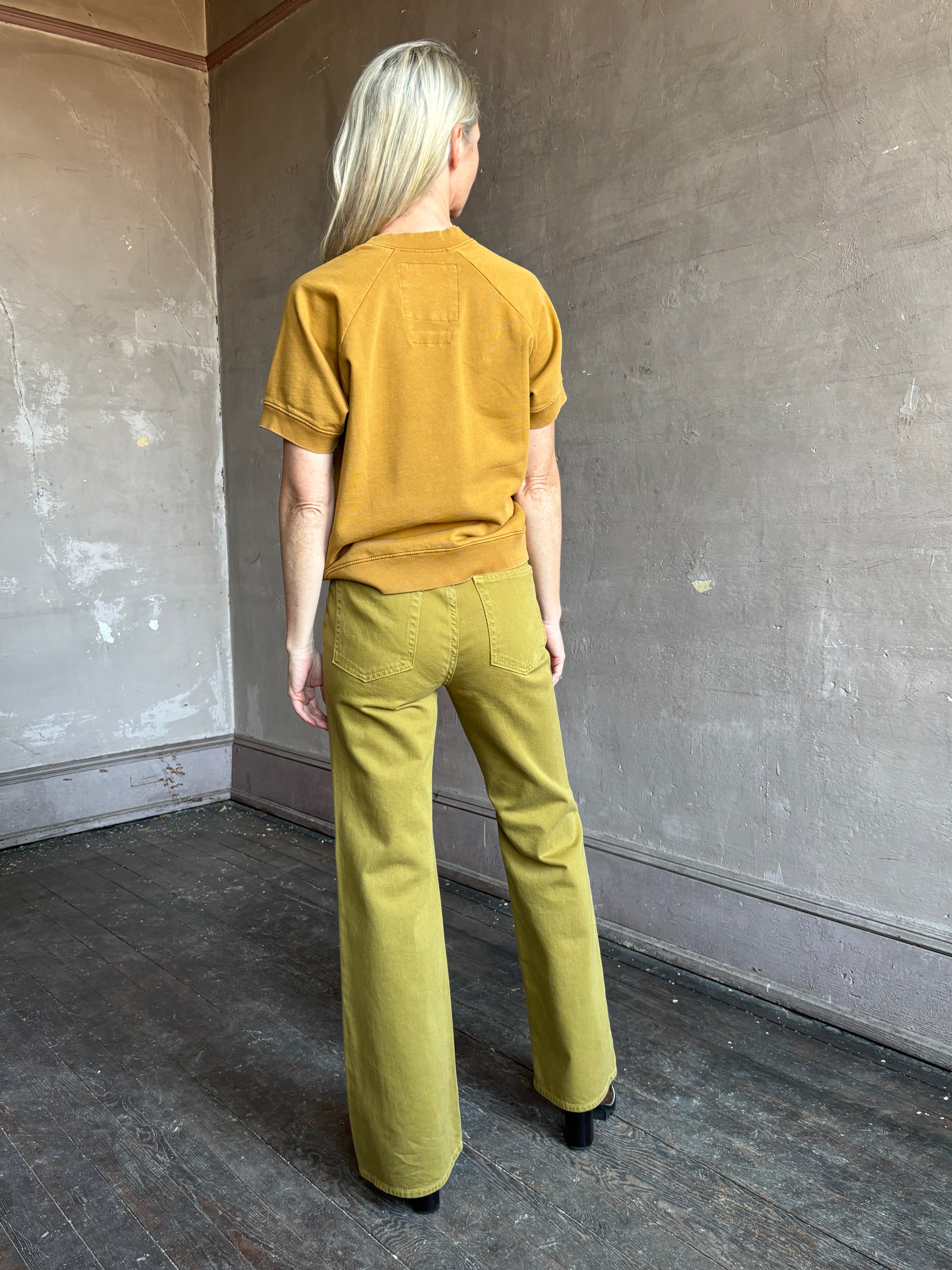 Image of mature woman wearing NY designer Rachel Comey Billi short sleeve sweatshirt in mustard gold 