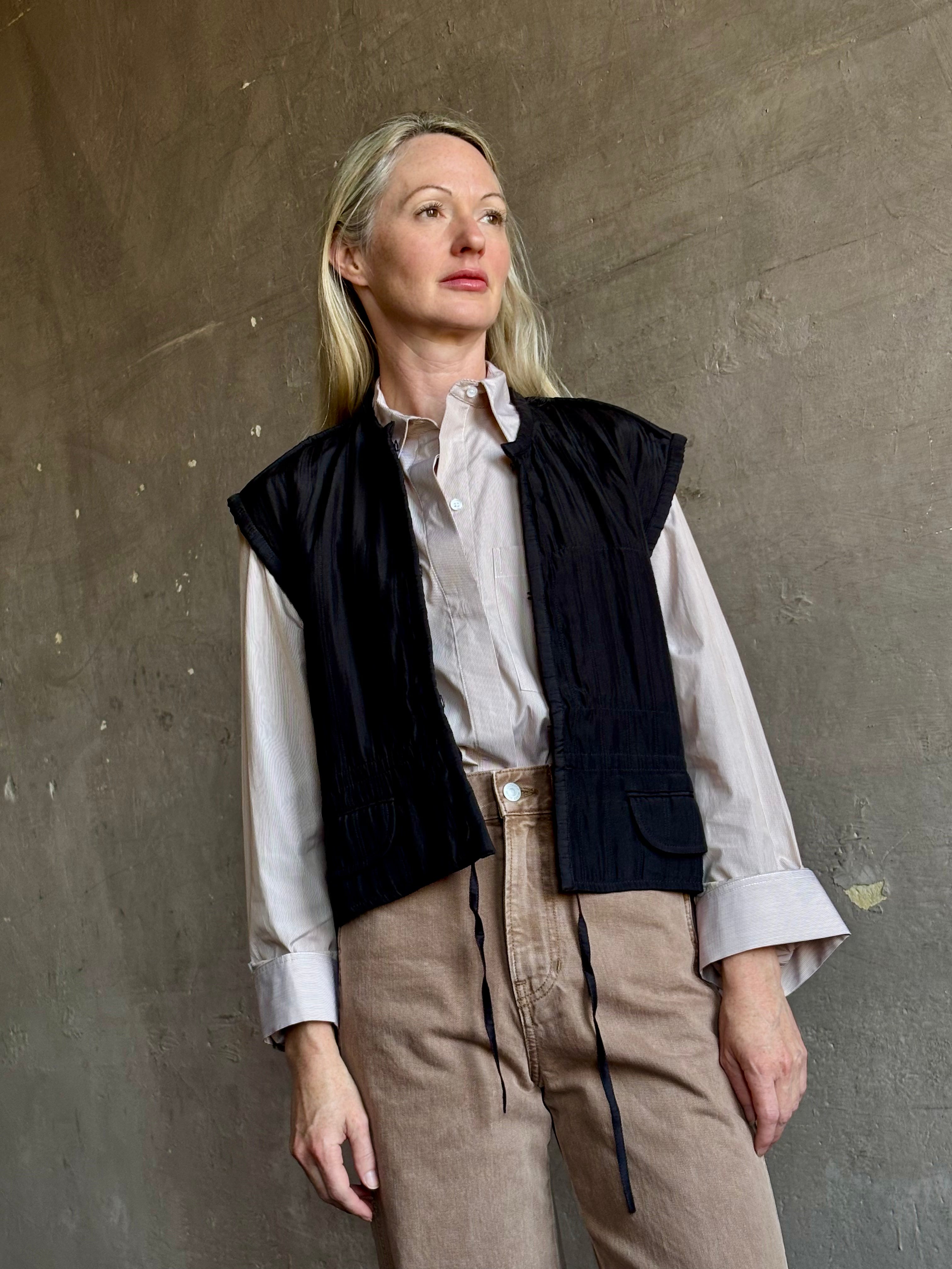 Image of mature model wearing American designer Rachel Comey Clifford quilted silk vest in solid black showcasing refined versatility