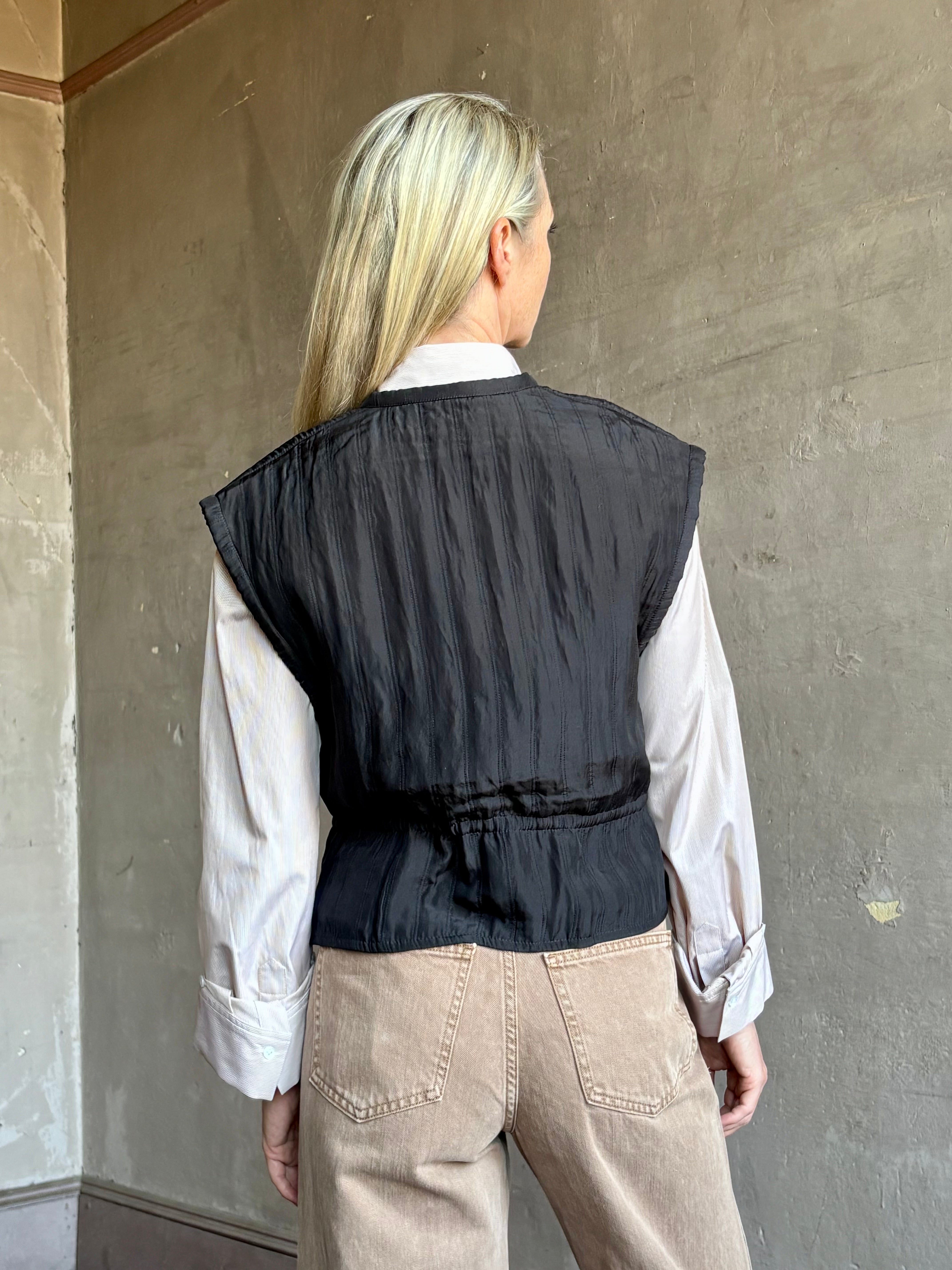 Image of mature model wearing American designer Rachel Comey Clifford quilted silk vest in solid black showcasing refined versatility