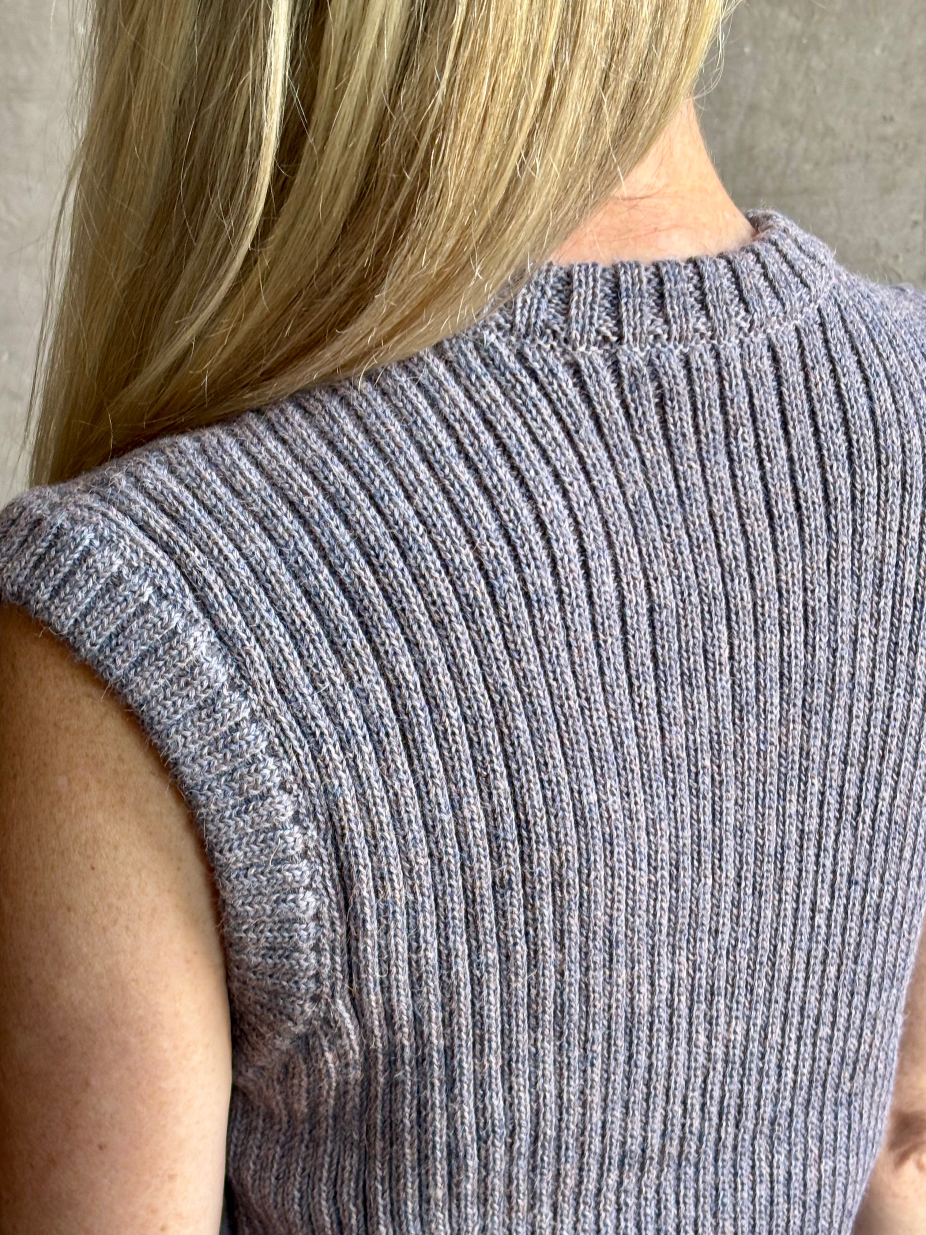 Mature woman wearing a quality lilac knit top fabricated from baby alpaca by designer Rachel Comey