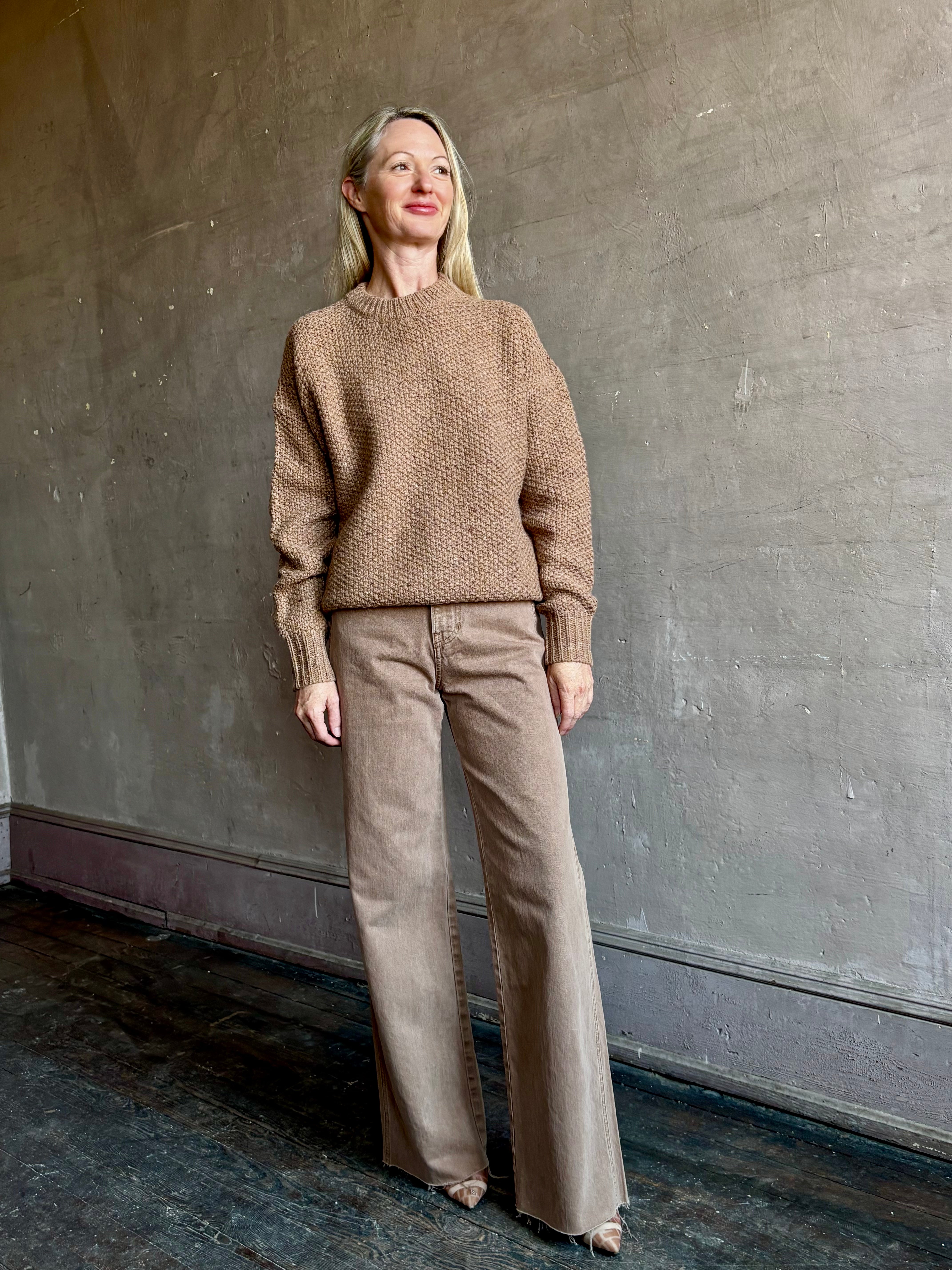 Image of mature woman wearing American designer Rachel Comey prescot sweater in a warm neutral colorway made with fine merino wool