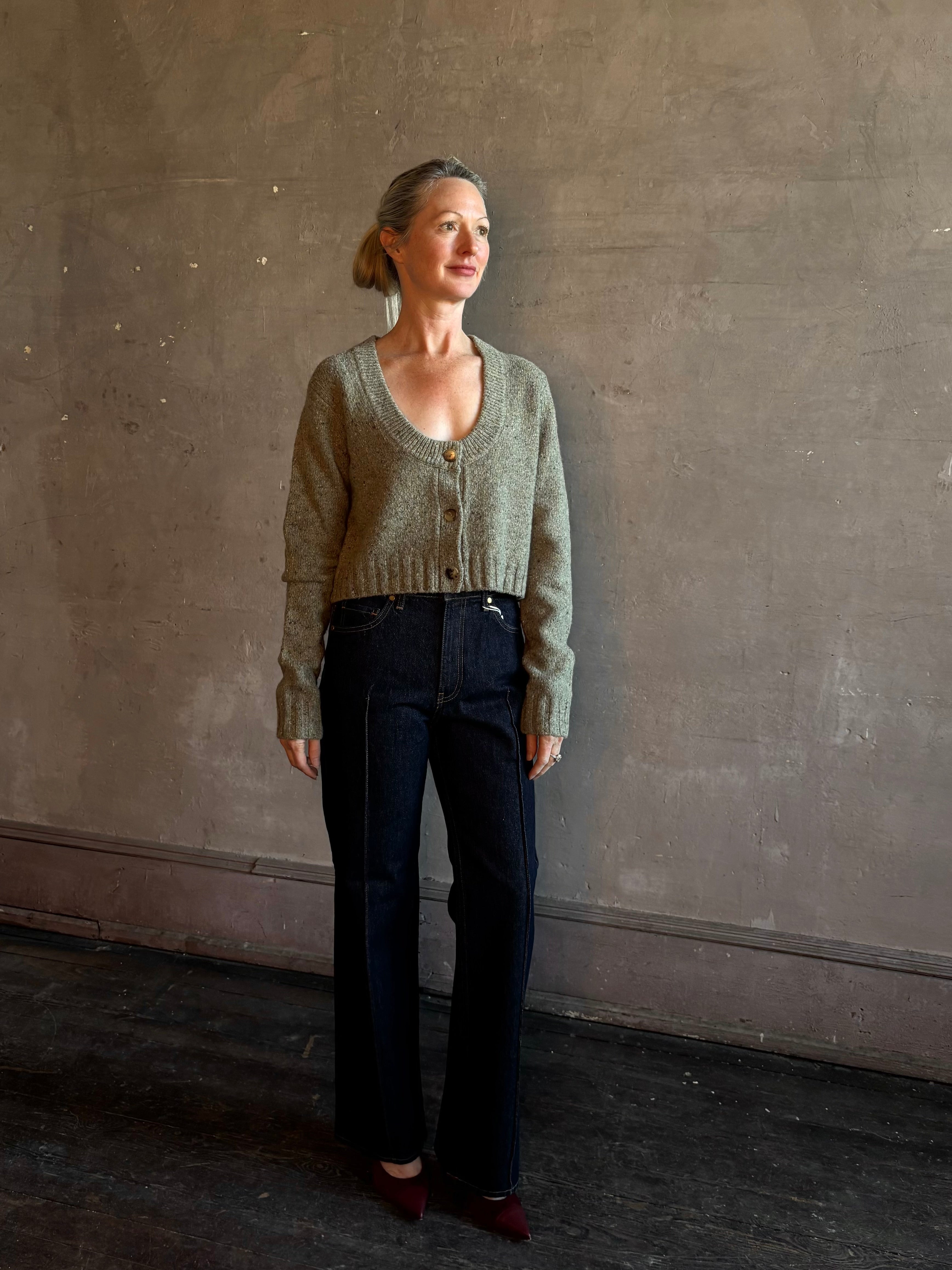 Mature woman wearing Rachel Comey Uridge Cardigan in Stone Green RWS-certified merino blend with U-neckline everyday layering