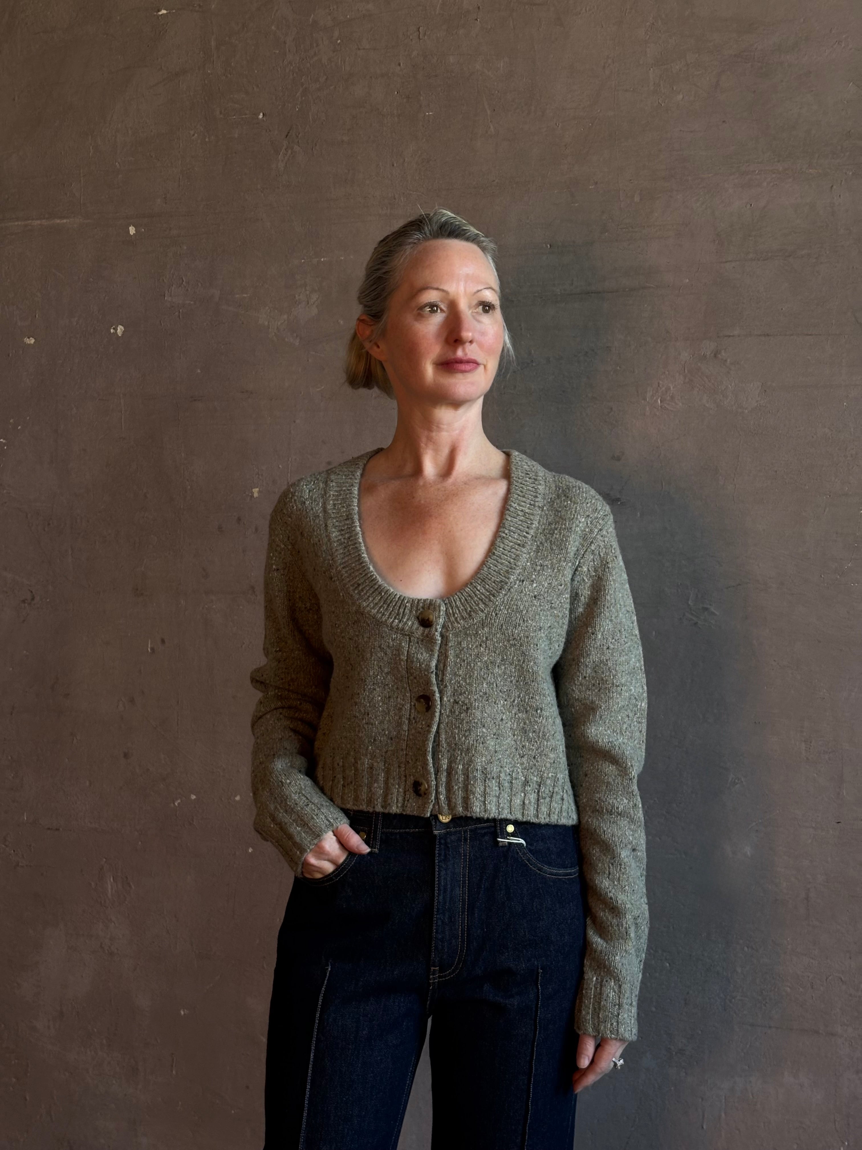 Mature woman wearing Rachel Comey Uridge Cardigan in Stone Green RWS-certified merino blend with U-neckline everyday layering