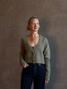 Mature woman wearing Rachel Comey Uridge Cardigan in Stone Green RWS-certified merino blend with U-neckline everyday layering