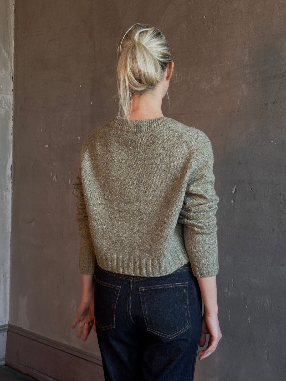 Mature woman wearing Rachel Comey Uridge Cardigan in Stone Green RWS-certified merino blend with U-neckline everyday layering