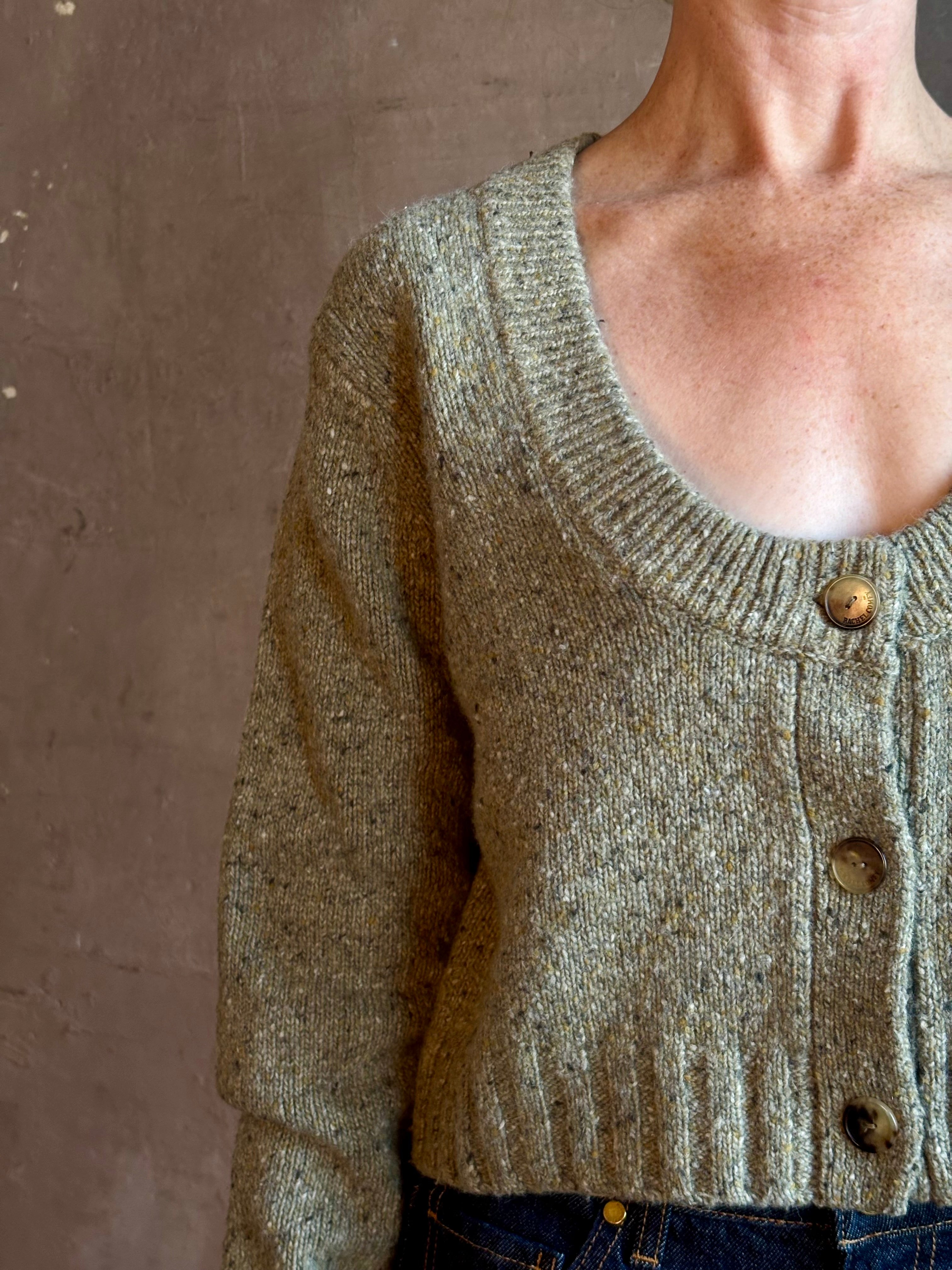 Mature woman wearing Rachel Comey Uridge Cardigan in Stone Green RWS-certified merino blend with U-neckline everyday layering