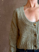 Mature woman wearing Rachel Comey Uridge Cardigan in Stone Green RWS-certified merino blend with U-neckline everyday layering