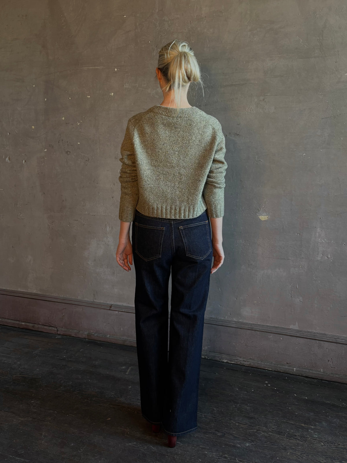 Mature woman wearing Rachel Comey Uridge Cardigan in Stone Green RWS-certified merino blend with U-neckline everyday layering